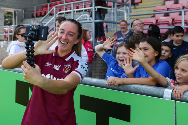 <p>Lisa Evans takes a photo with young fans after West Ham’s WSL match against Aston Villa</p>
