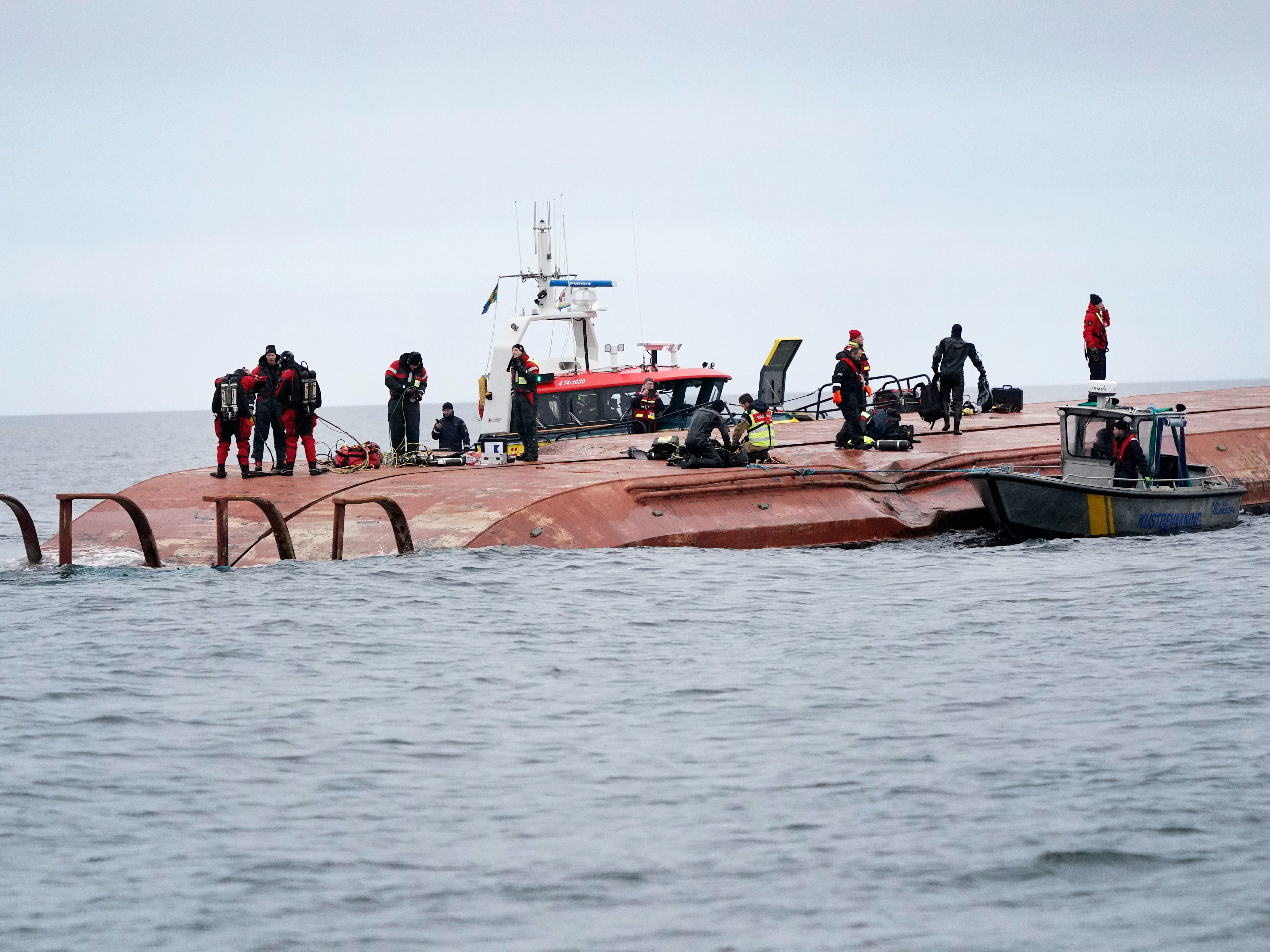 Divers work on the capsized Danish ship Karin Hoej after it collided with British vessel Scot Carrier in the Baltic Sea.