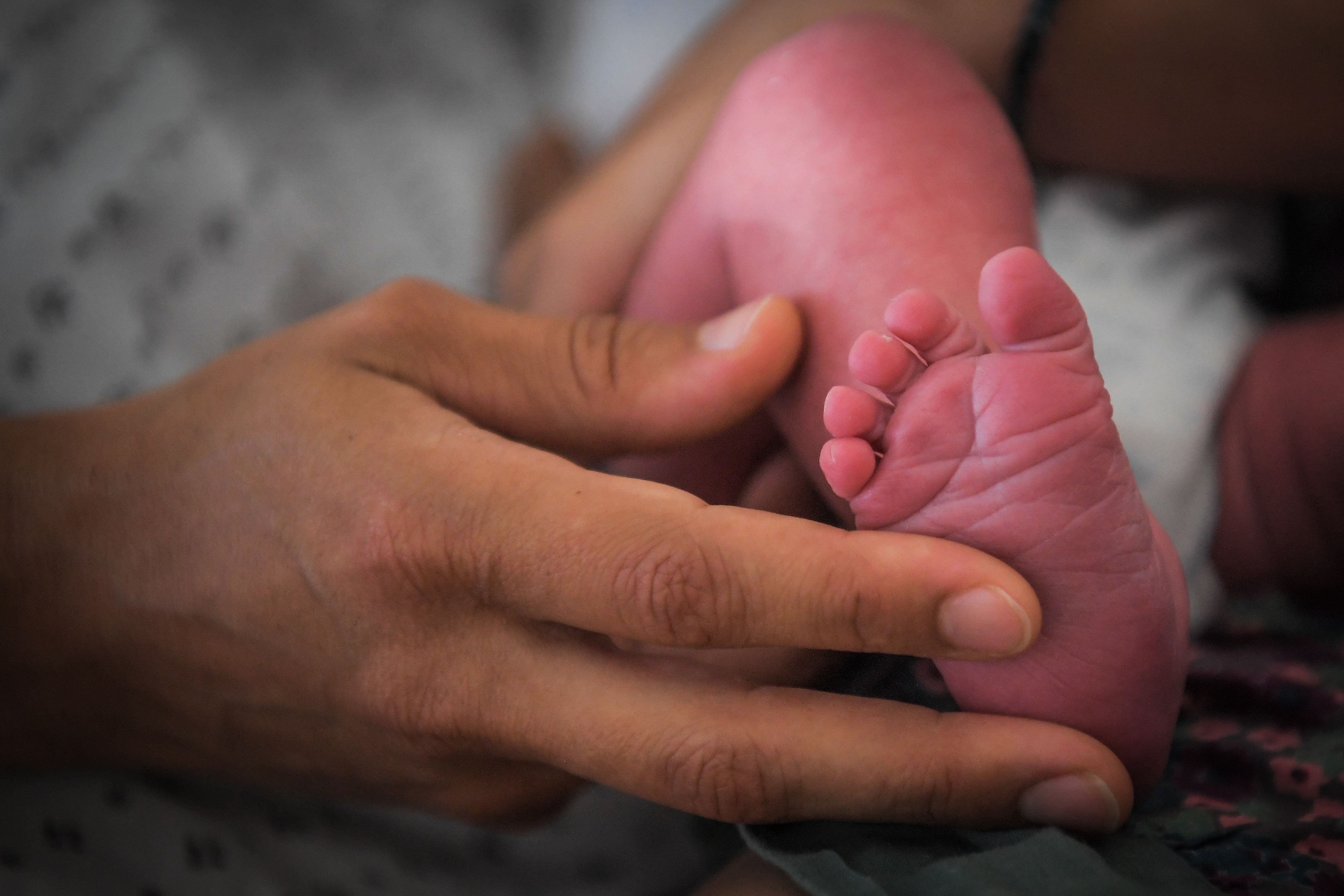 Representational: A mother holds the foot of her newborn baby
