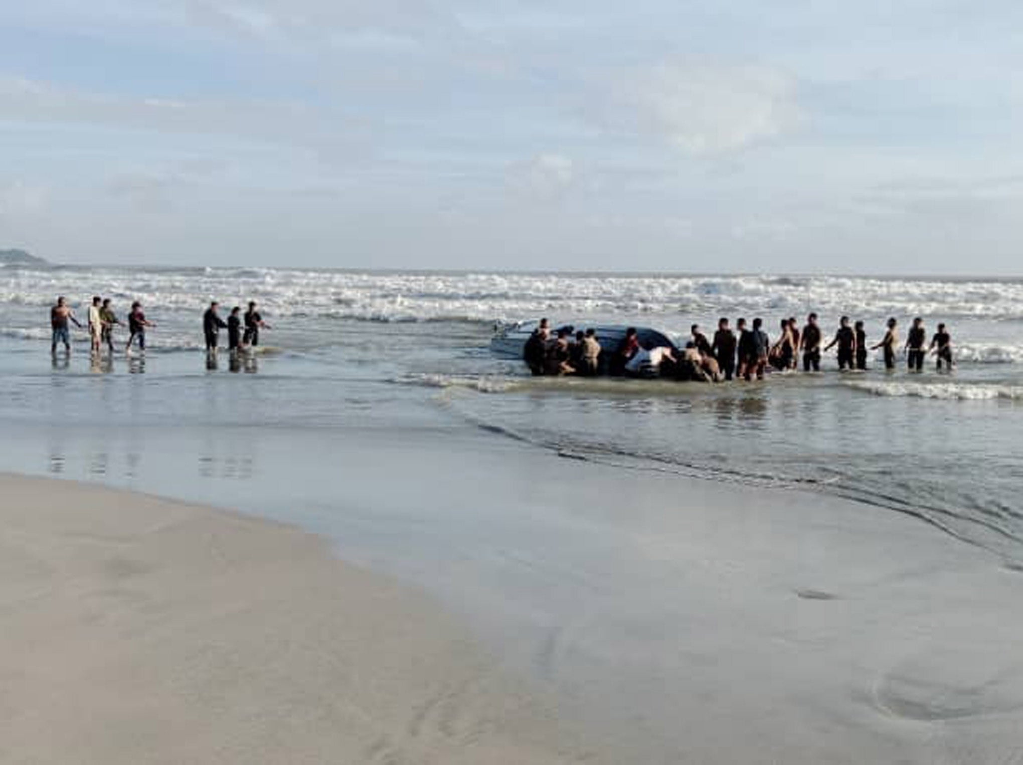 Malaysian authorities recover a capsized boat on the Tanjung Balau Beach in Kota Tinggi, Johor State on 15 December