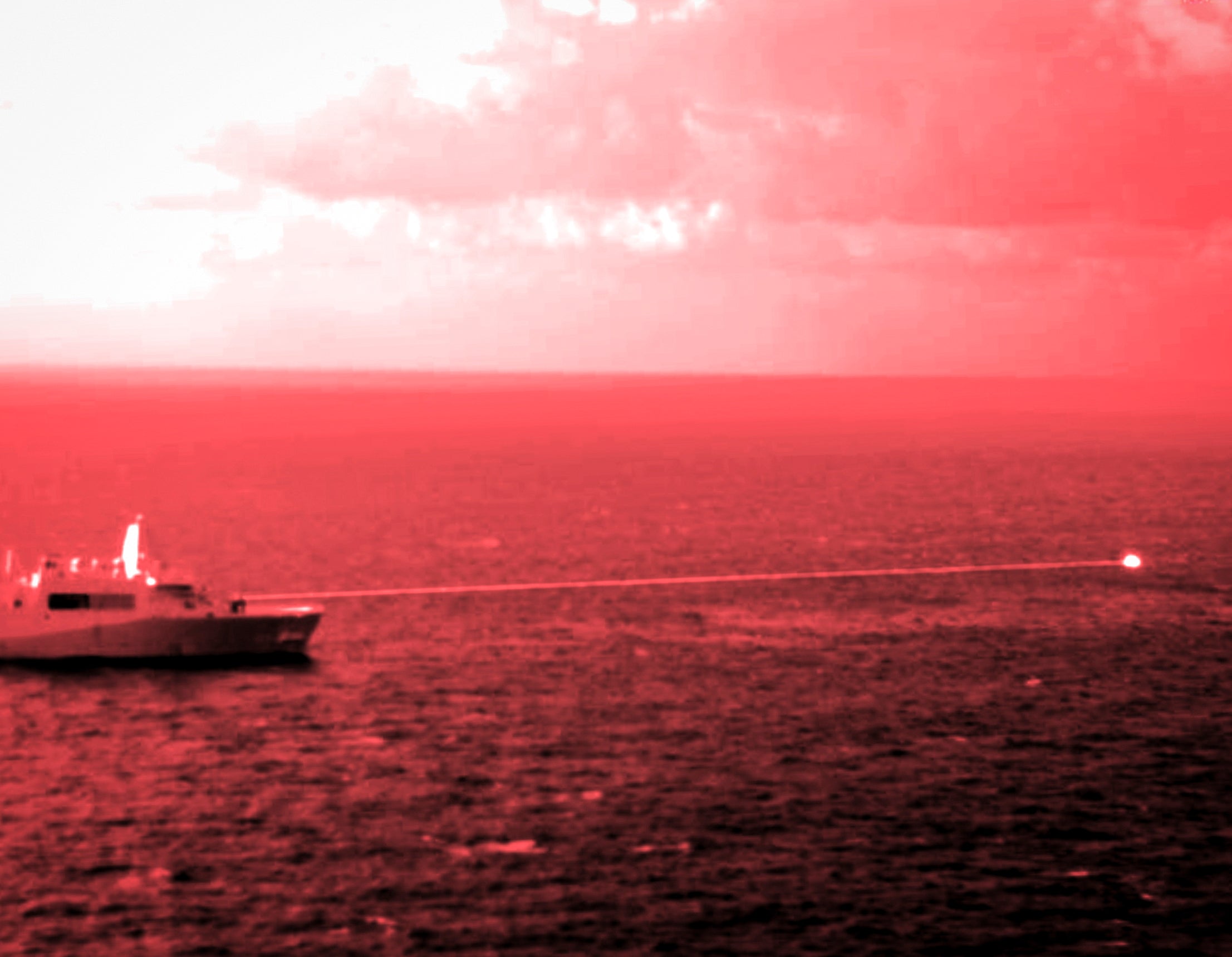 In this handout infrared photo from the U.S. Marine Corps, the USS Portland fires a laser weapon system at a target floating in the Gulf of Aden on Tuesday, Dec. 14, 2021. The U.S. Navy announced Wednesday it tested a laser weapon and destroyed a floating target in the Mideast, a system that could be used to counter bomb-laden drone boats deployed by Yemen's Houthi rebels in the Red Sea.
