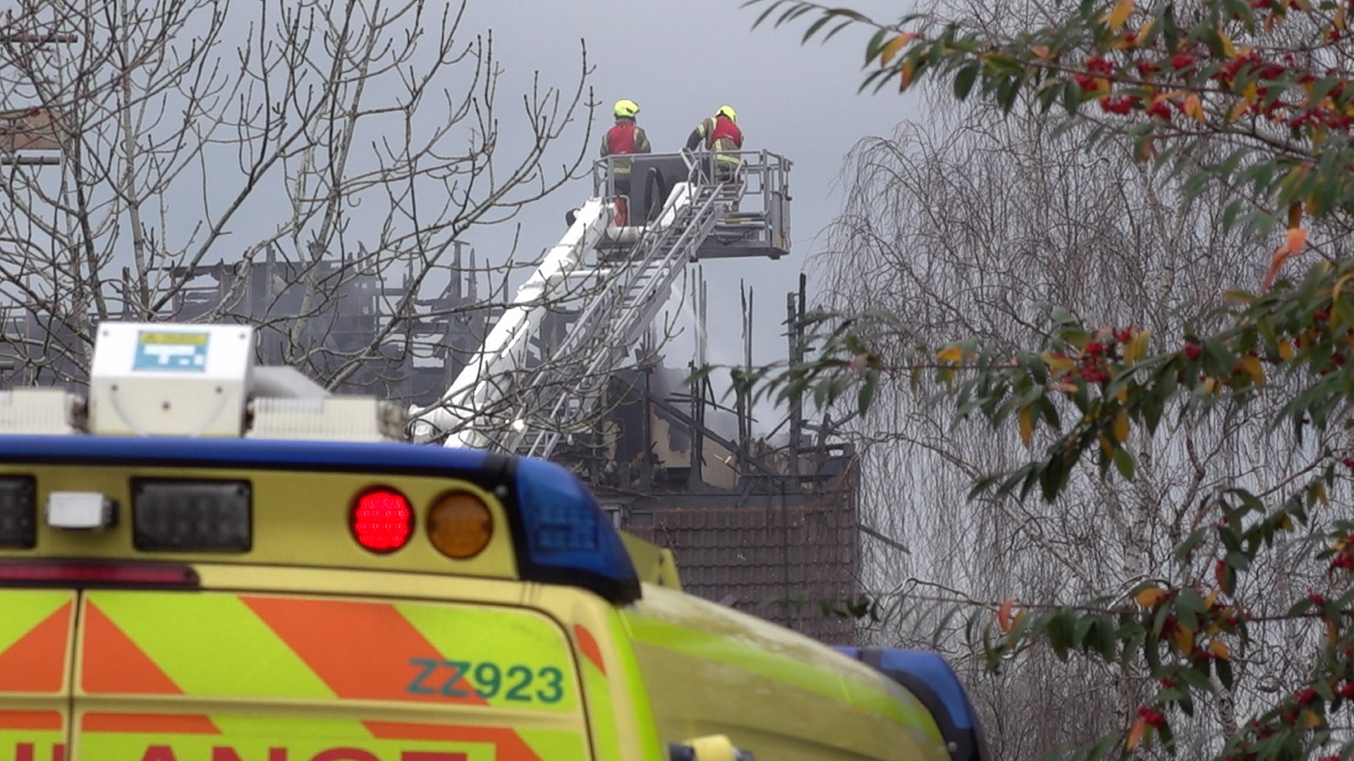 Firefighters view the destroyed building from a raised platform (Marc Ward/PA)