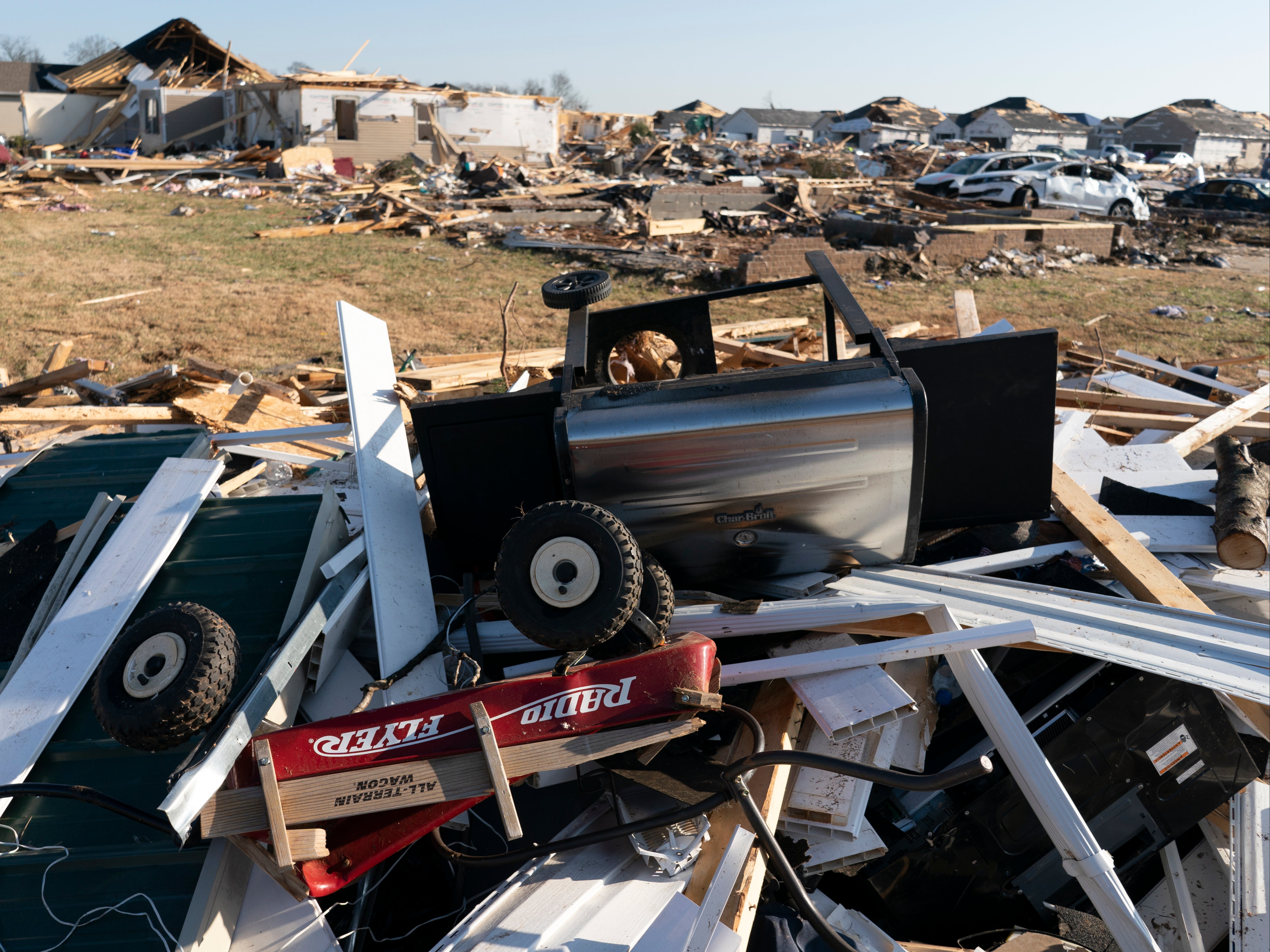 A Radio Flyer wagon lies among debris along Moss Creek Avenue Tuesday, Dec. 14, 2021, in Bowling Green