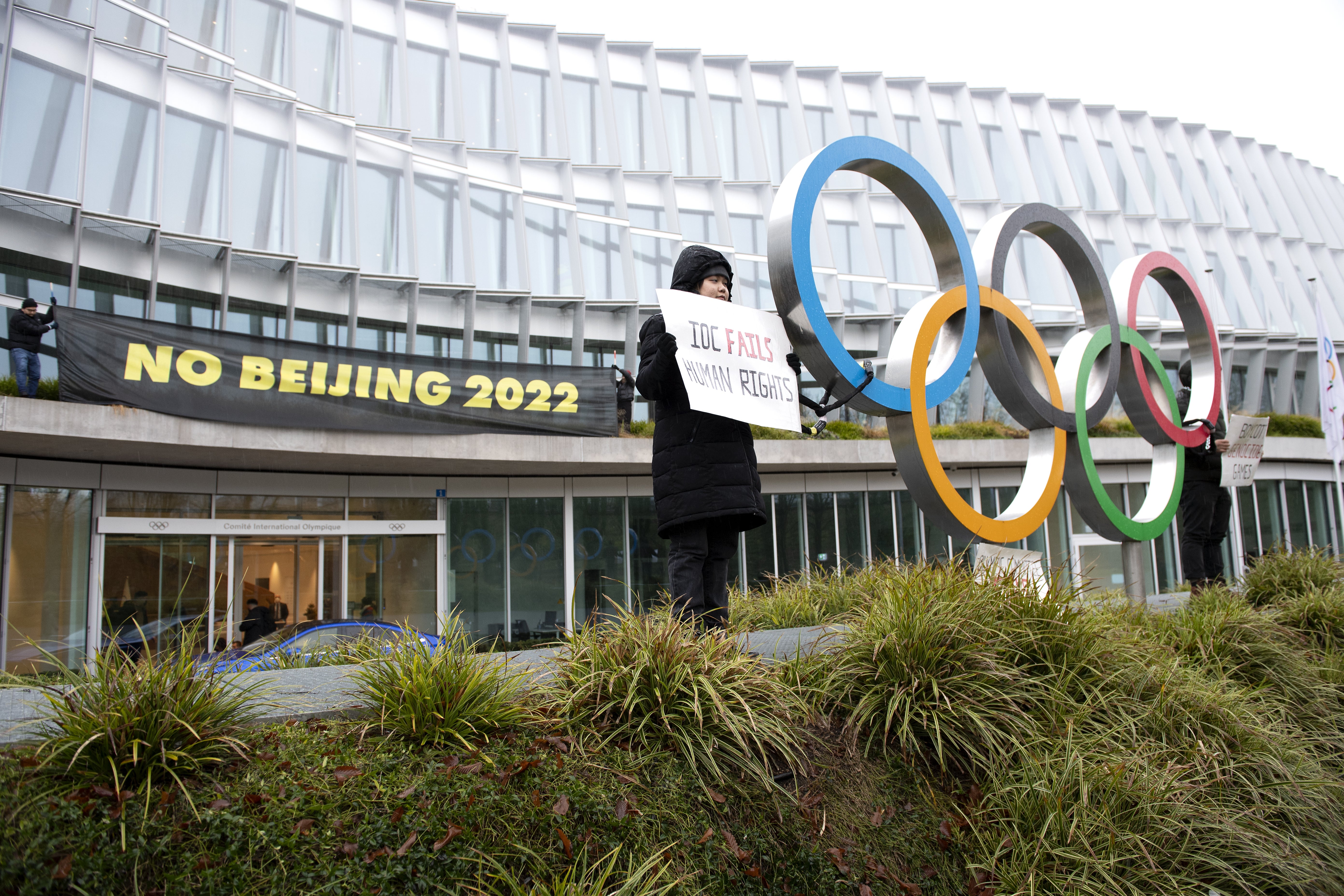 Protesters against Beijing 2022 Winter Olympics stand in front of the IOC headquarters in Switzerland