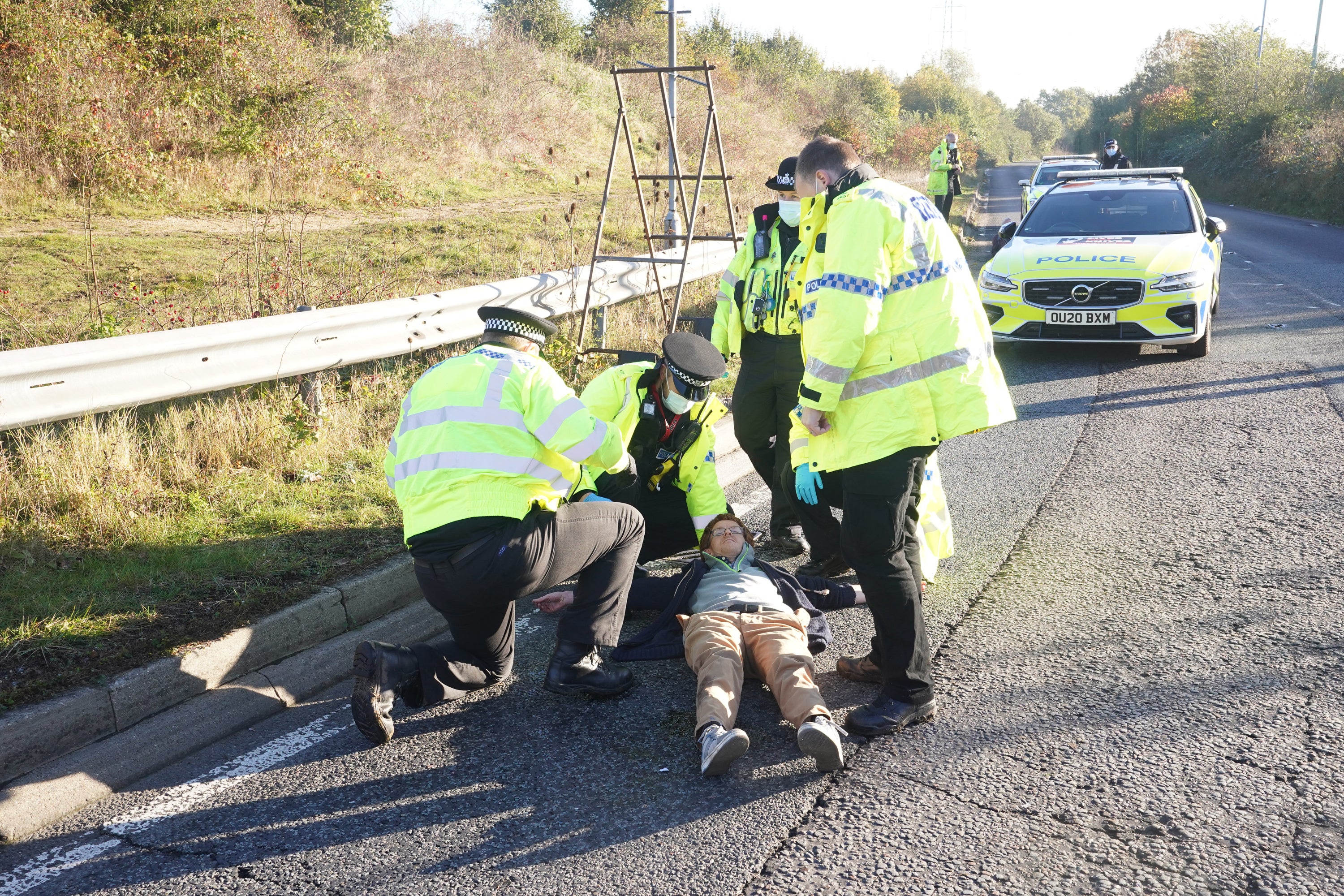 Police officers detain a protester in November at an Insulate Britain roadblock near to the South Mimms roundabout at the junction of the M25 and A1 (PA)