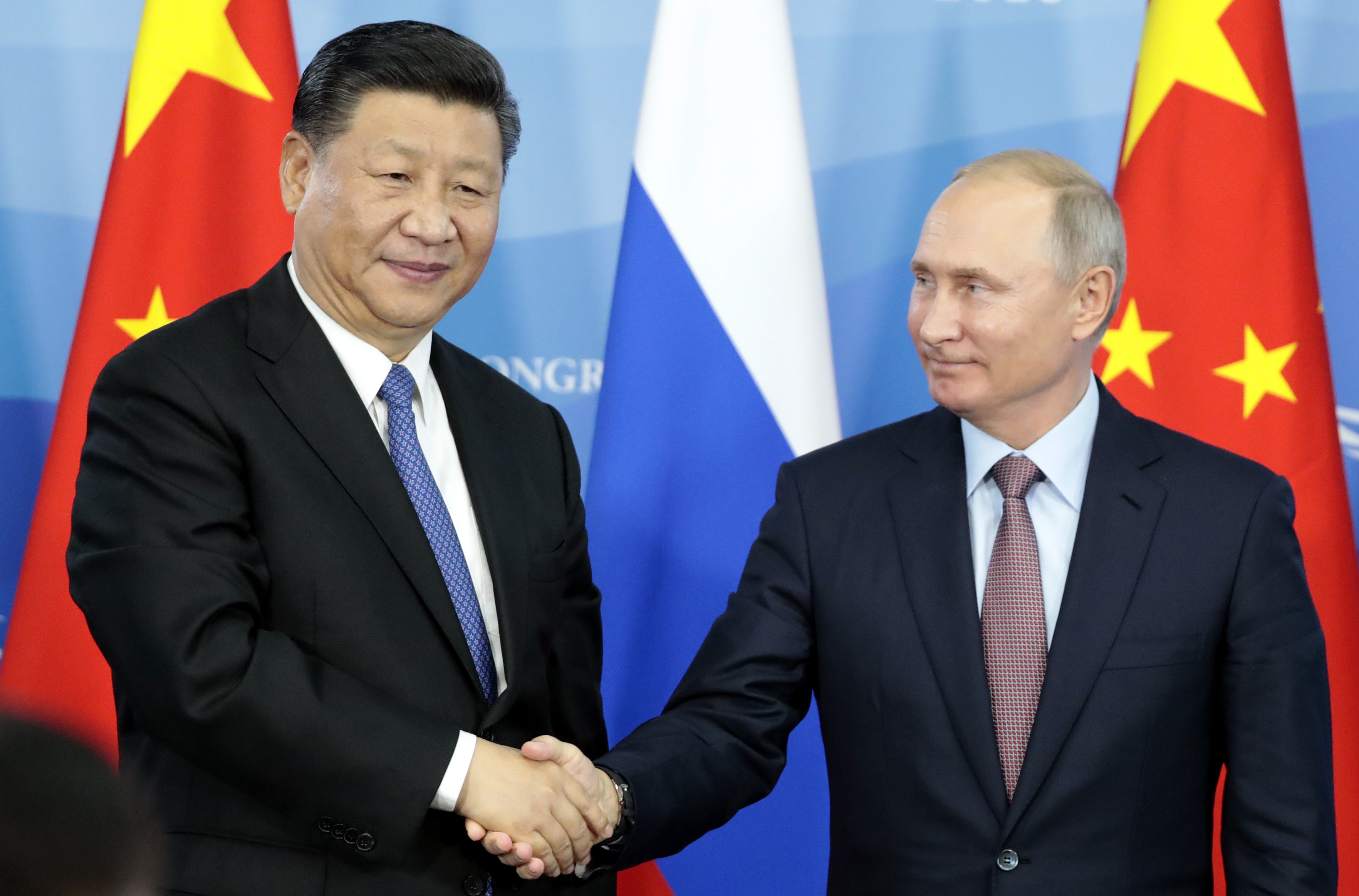 File: Russia’s President Vladimir Putin (R) shakes hands with his China’s counterpart Xi Jinping