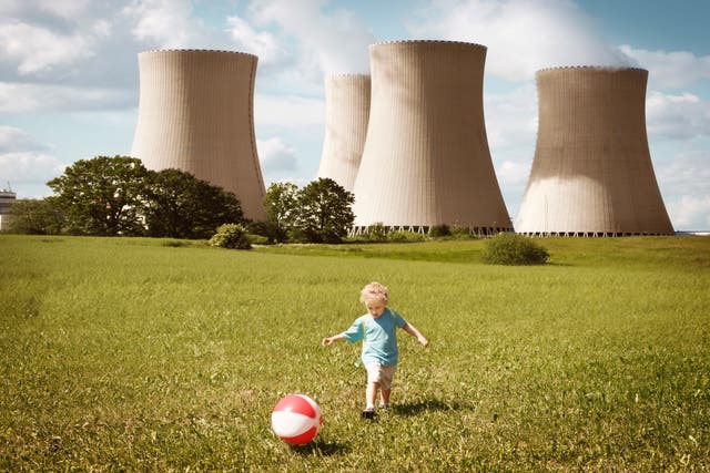 <p>A child plays in front of cooling towers. Scientists have said fossil fuels are having a “major” negative impact on human reproductivity</p>