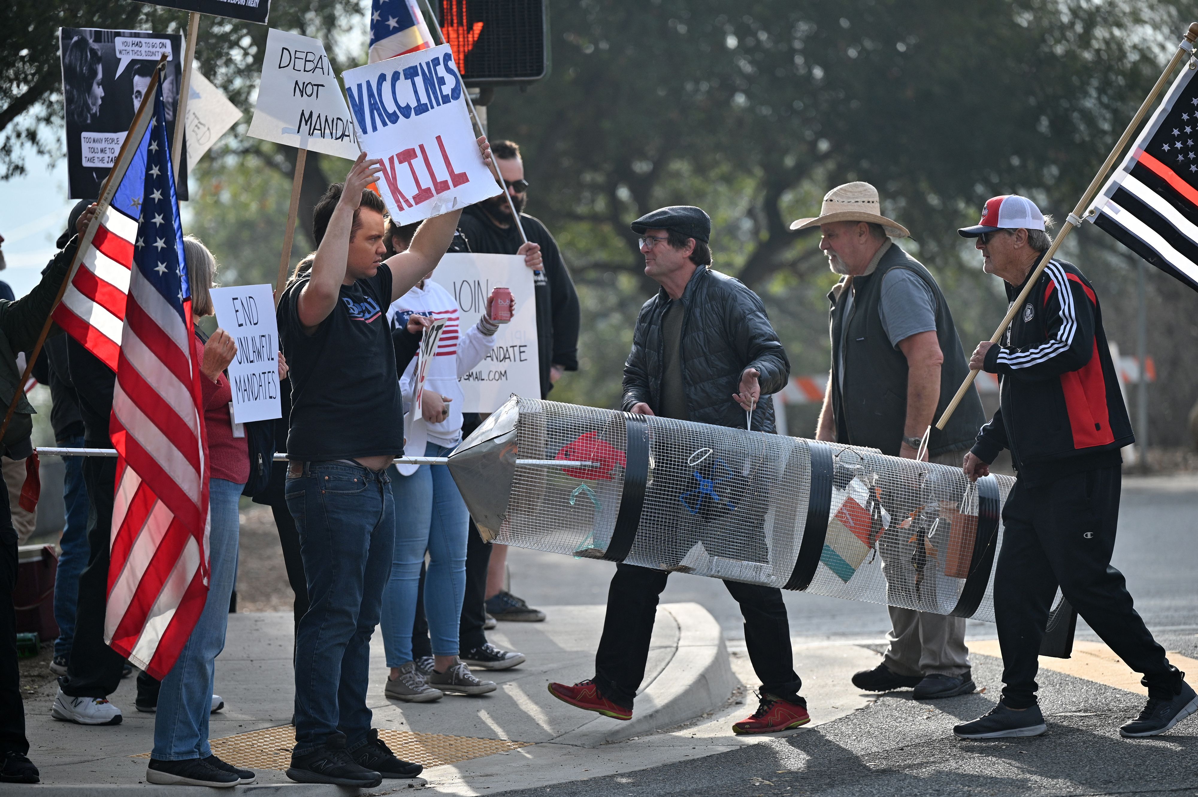 Workers at Nasa’s Jet Propulsion Laboratory (JPL) and their supporters carry a representation of a syringe during a protest on 1 November outside JPL in Pasadena, California against a US government mandate requiring all federal employees to received the Covid-19 coronavirus vaccine