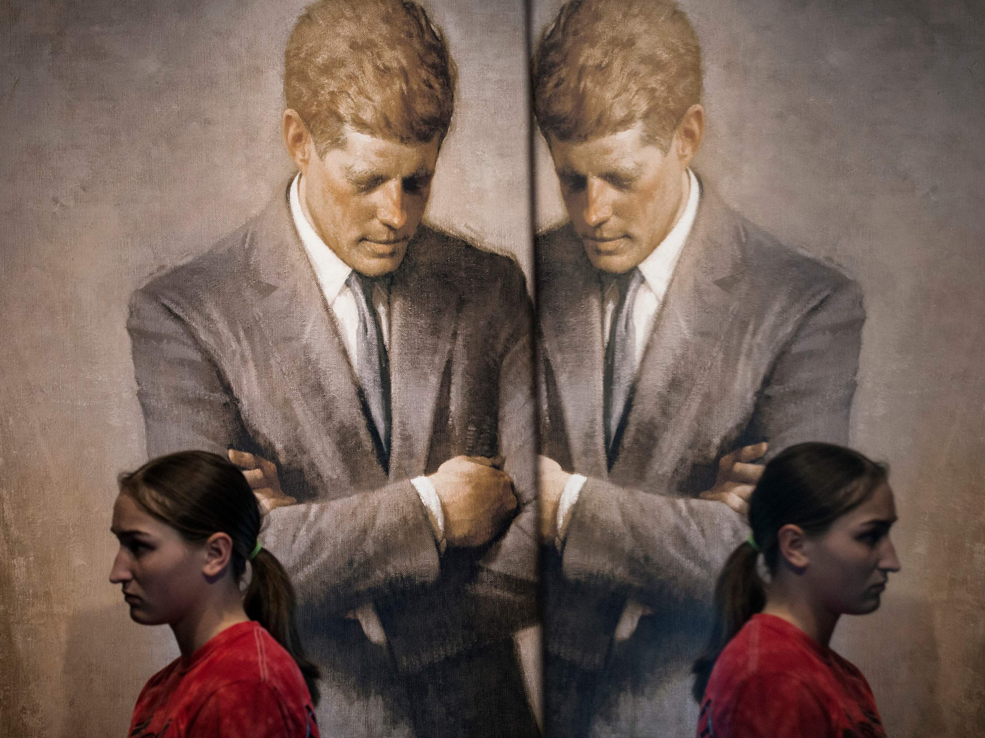 A student walks past the portrait of John F Kenndy that hangs in the White House in 2013