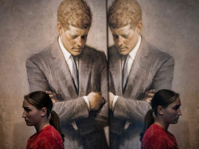 <p>A student walks past the portrait of John F Kenndy that hangs in the White House in 2013</p>