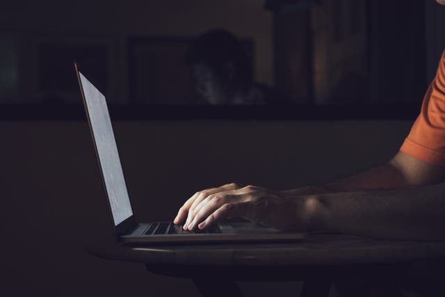 <p>Man typing on a computer at night </p>