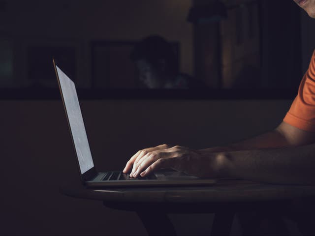 <p>Man typing on a computer at night </p>