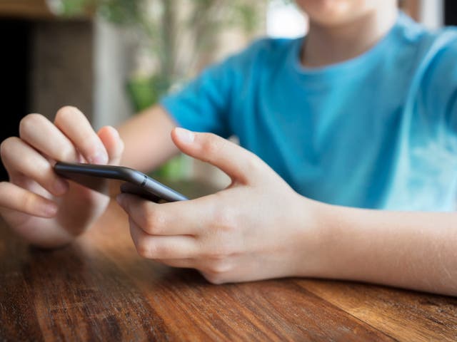 A young boy uses a smartphone