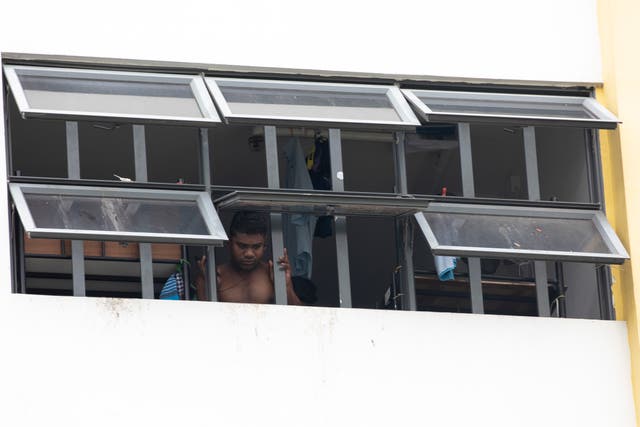<p>A migrant worker locked down in a dormitory in Singapore</p>
