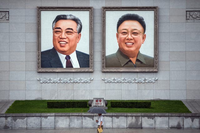 <p>File: People walk beneath huge pictures of Kim Il-sung and Kim Jong-il displayed from the Parade Reviewing Stand in Kim il-Sung Square, on 23 August 2018 in Pyongyang, North Korea</p>