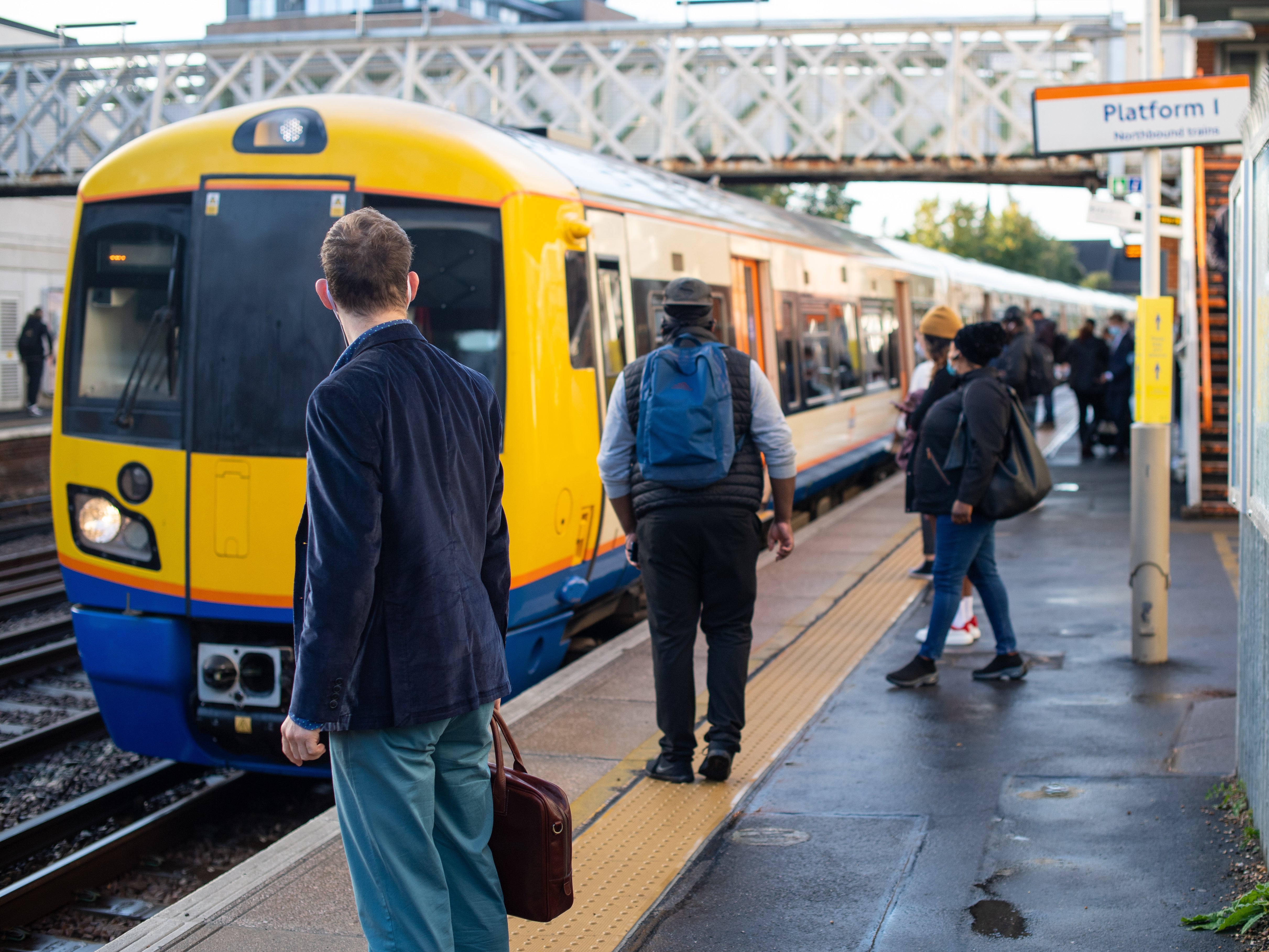 Commuters await a train in south London