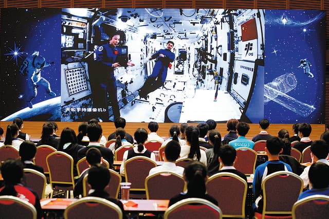 <p>Shenzhou XIII crew members Wang Yaping (left) and Ye Guangfu give a lecture to students from China’s space station on 9 December </p>