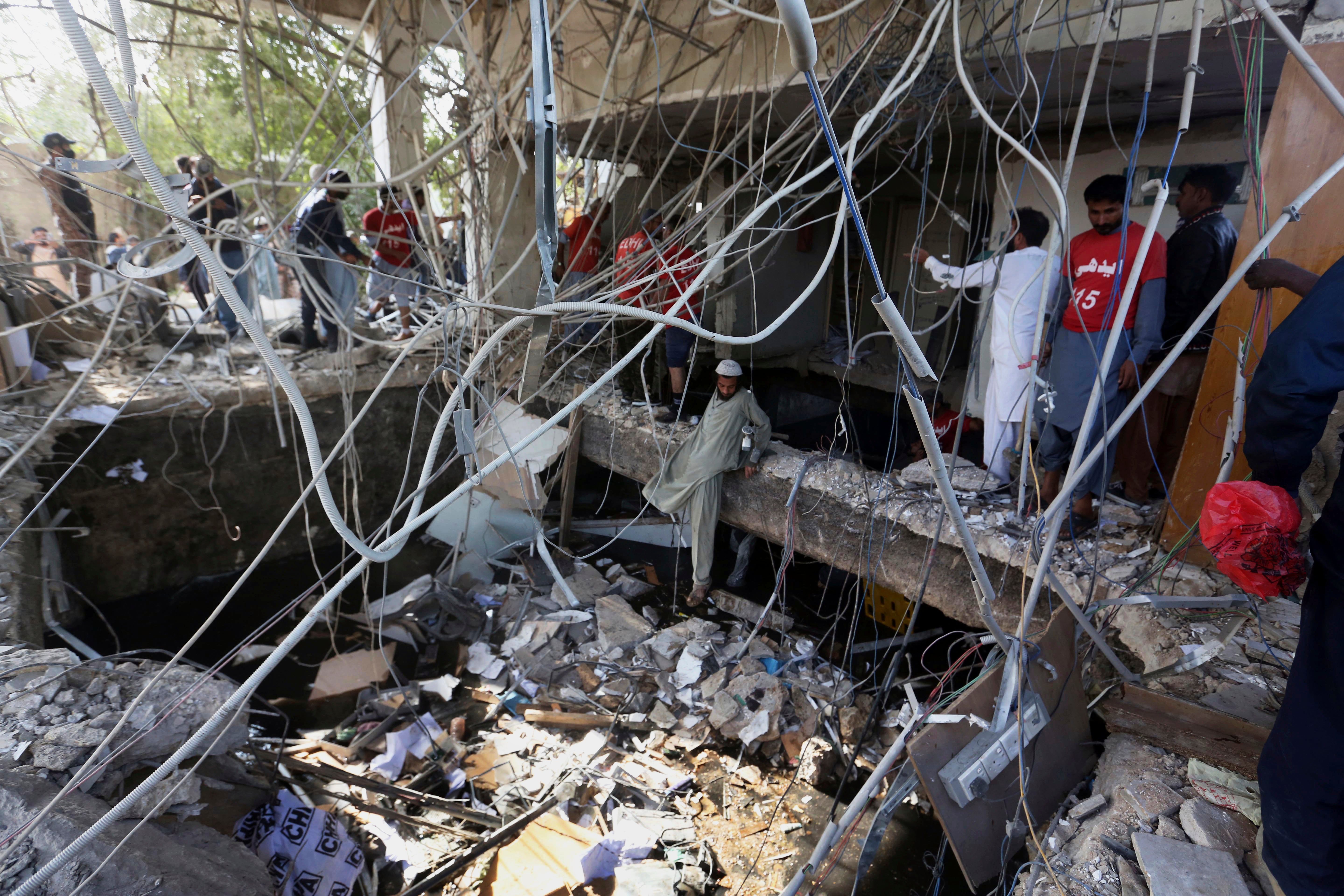 Rescuers inspect the scene of a gas explosion in Karachi, Pakistan, Saturday,