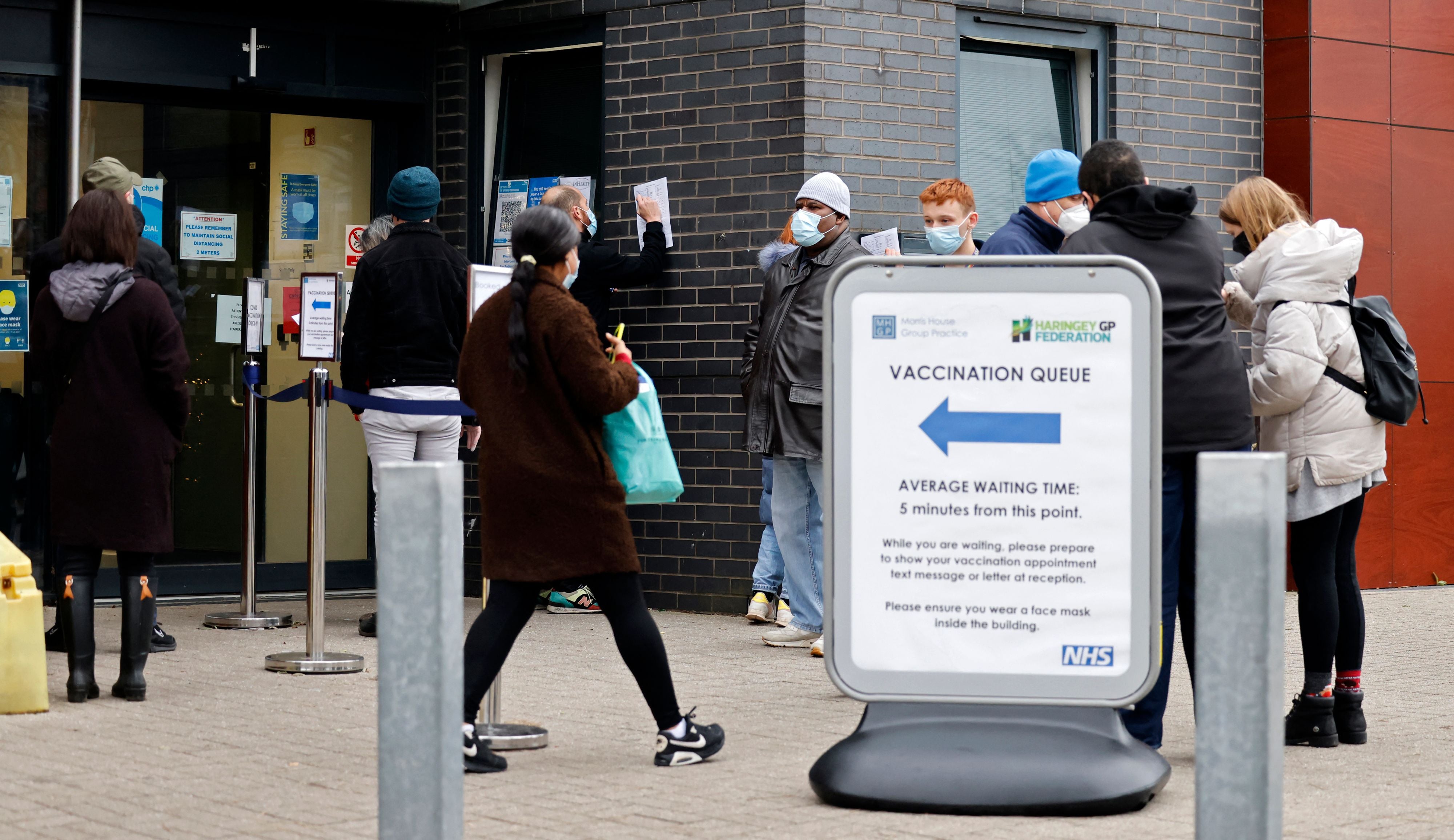 Members of the public queue to receive a first, second or booster dose of a Covid-19 vaccine, outside a 24-hour vaccination centre, in north east London on December 18.