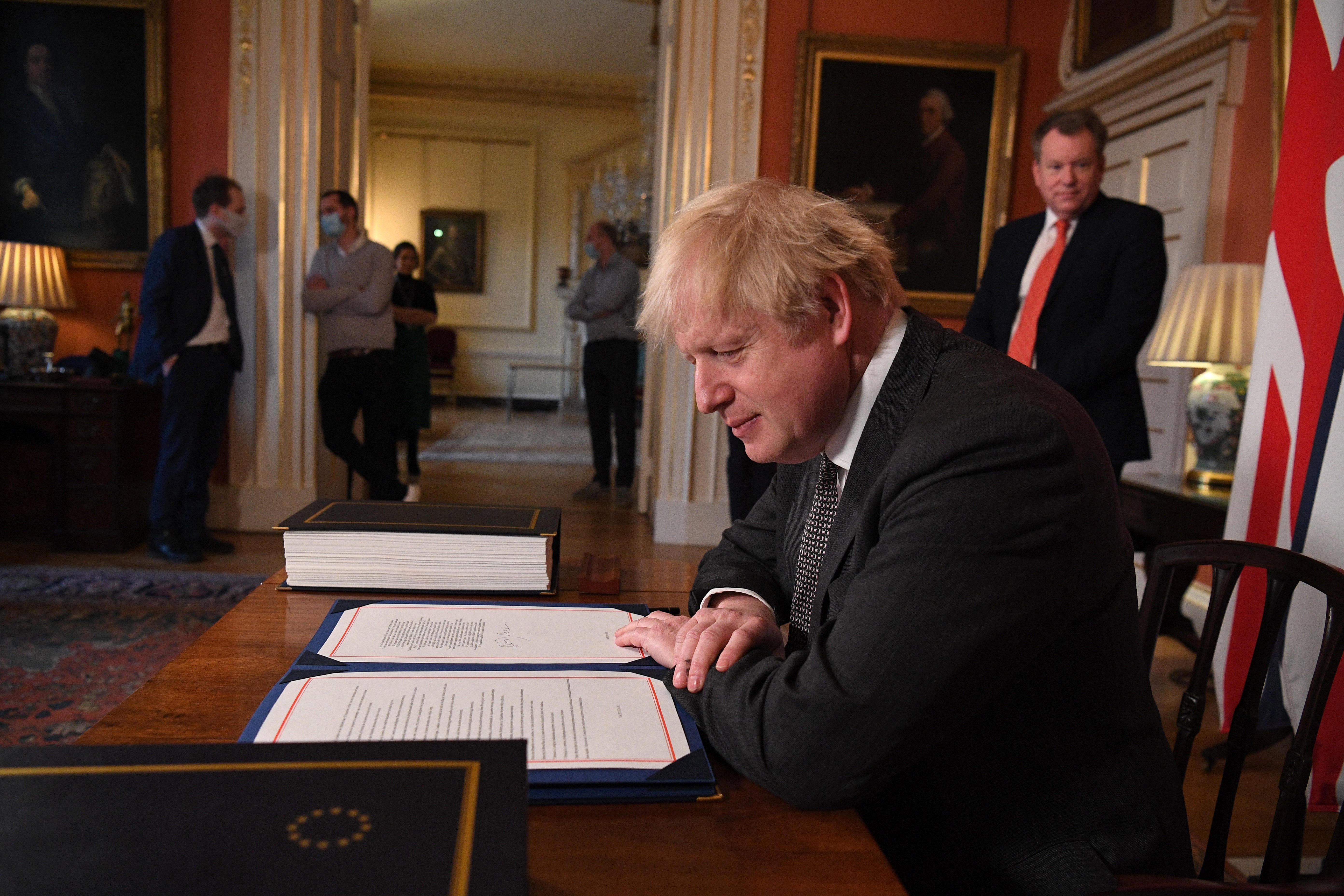 David Frost looks on as Boris Johnson prepares to sign the EU-UK Trade and Cooperation Agreement in 2020