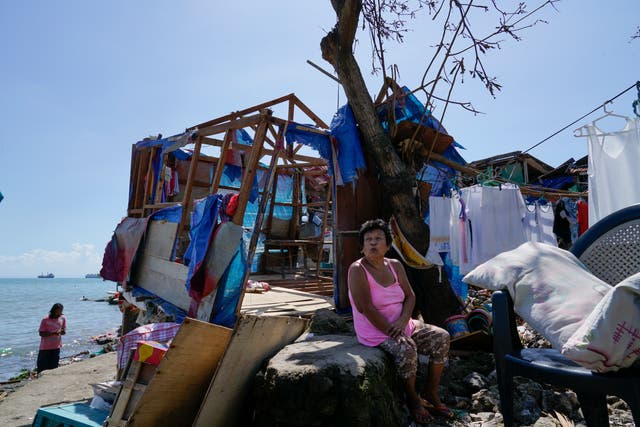 <p>A woman sits beside damaged homes due to Typhoon Rai in Talisay, Cebu province in central Philippines on 18 December </p>