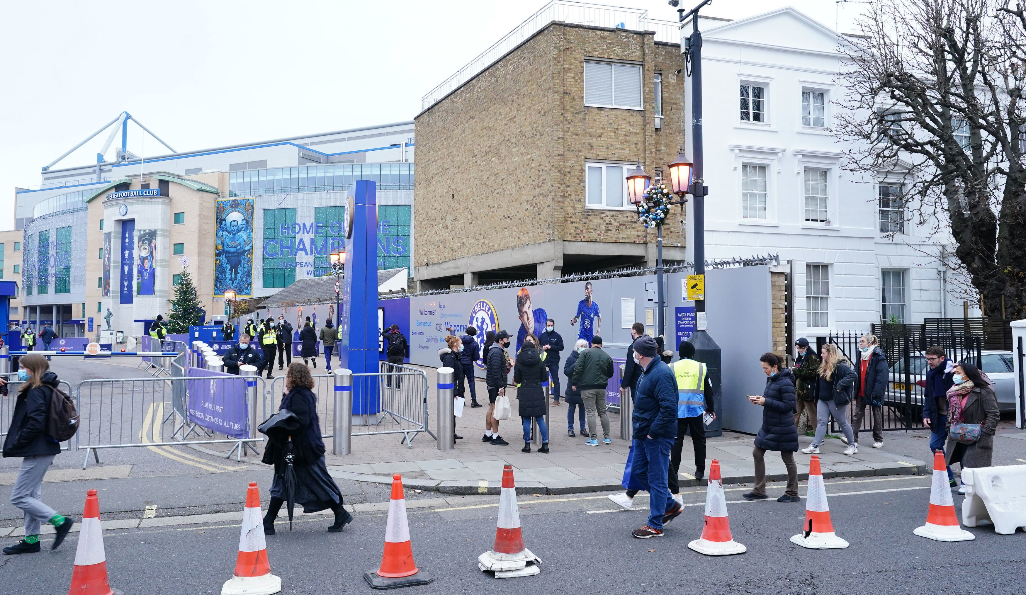 People queue for a booster in a pop-up clinic at Chelsea FC’s Stamford Bridge Stadium (Ian West/PA)