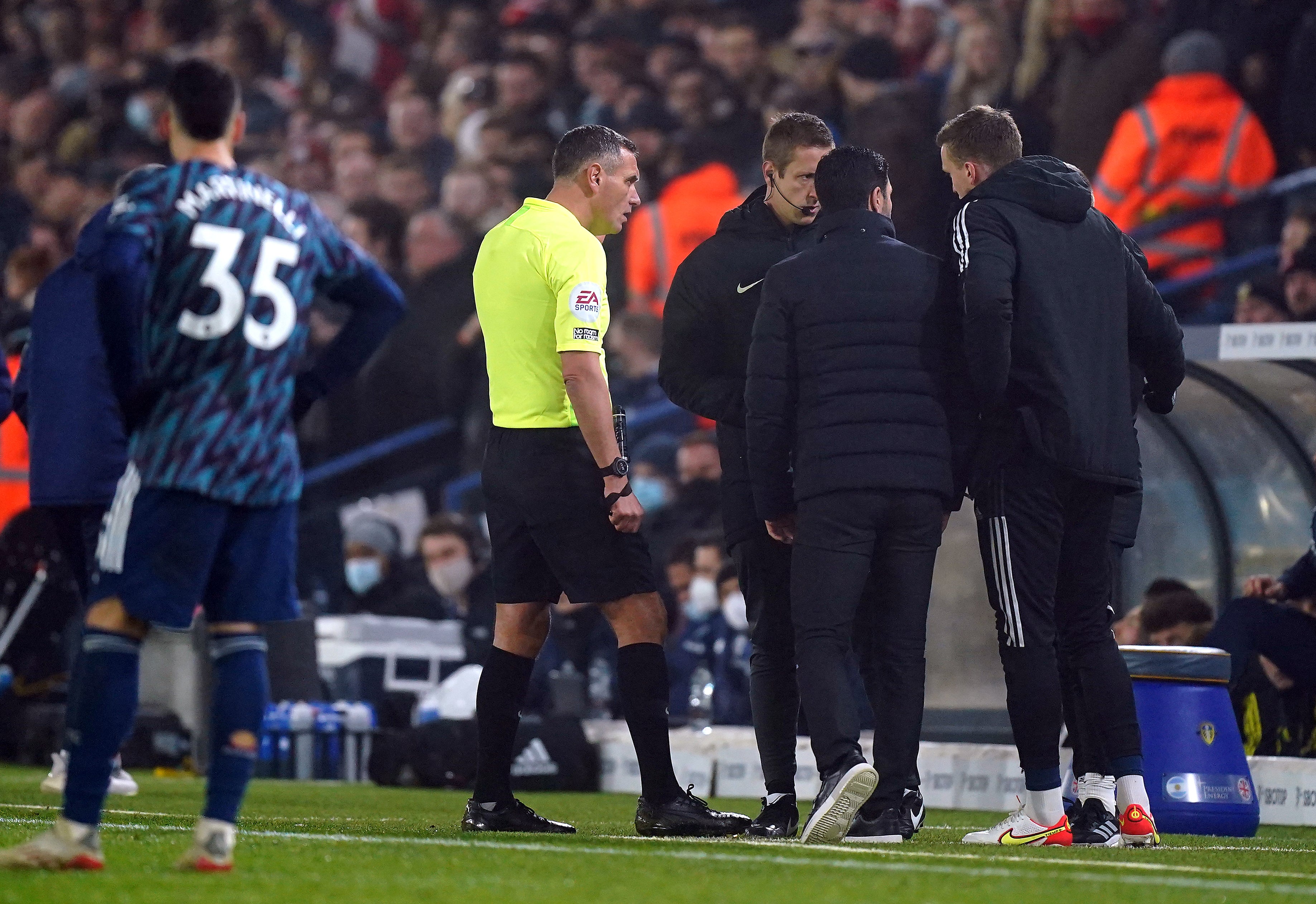 Arsenal manager Mikel Arteta, centre, speaks with referee Andre Marriner, left, and fourth official John Brooks after alleged racist abuse was aimed at the Arsenal bench in Leeds (Mike Egerton/PA)