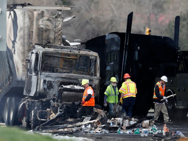 Los trabajadores limpian los escombros de los carriles en dirección este de la Interestatal 70 el 26 de abril de 2019, en Lakewood, Colorado, luego de un choque mortal que involucró a un camión que transportaba madera