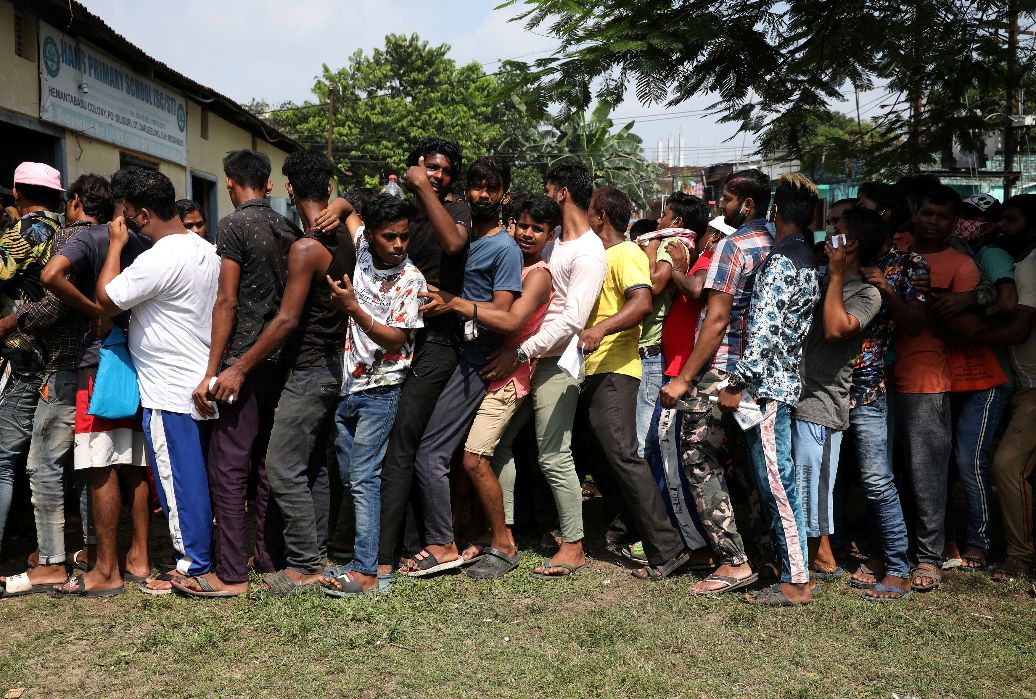 People queue up to receive a dose of the Covishield vaccine outside a vaccination centre in Siliguri, West Bengal