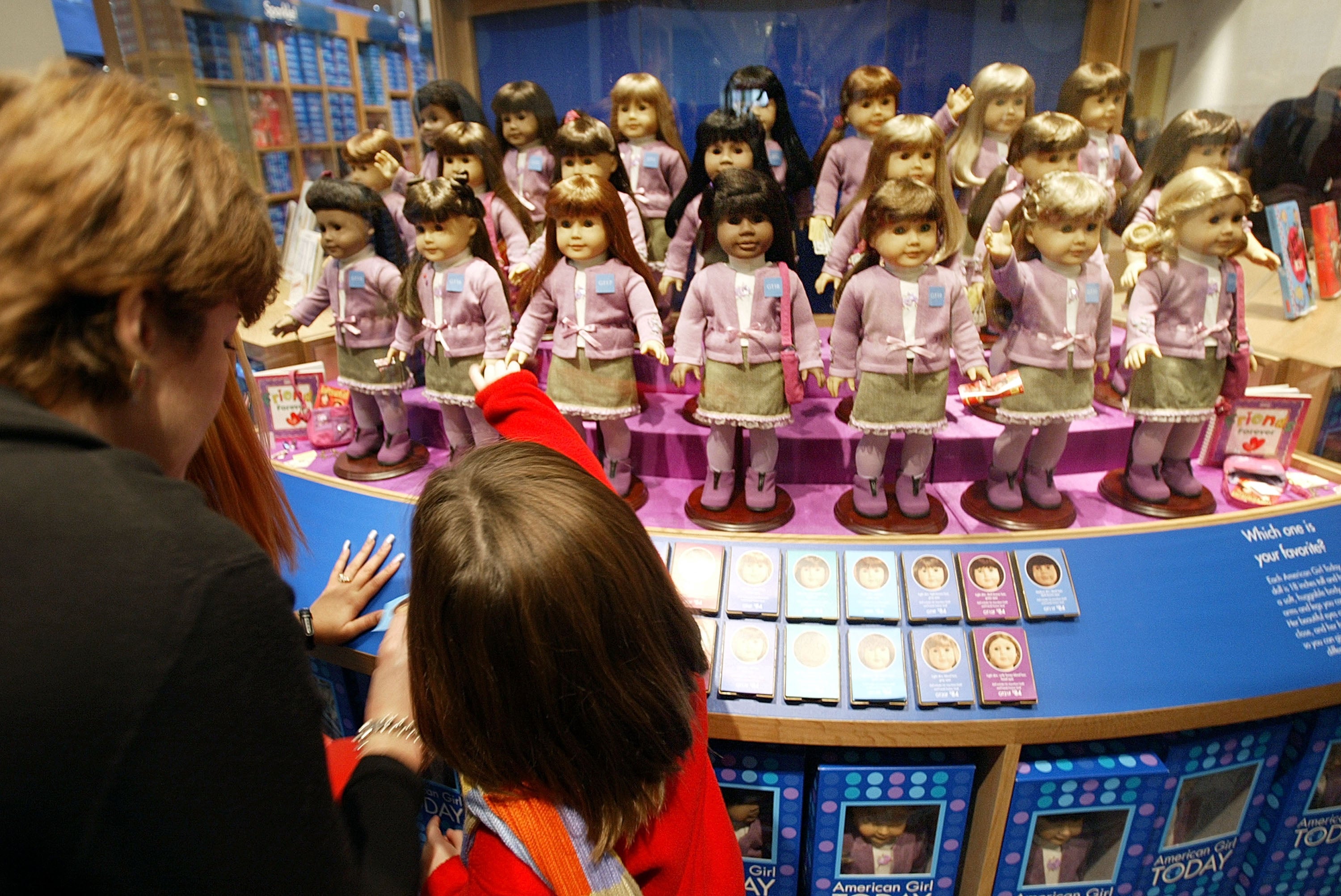 A woman and child view dolls for sale at a press preview for the opening of American Girl Place New York November 7, 2003 in New York City.