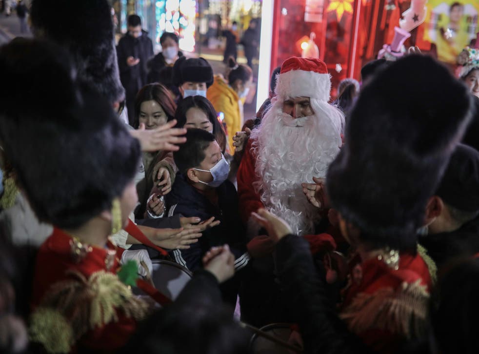 <p>File photo: A person dressed as Santa Claus distributes gifts to people outside a shopping complex in Beijing, China, 25 December 2020</p>