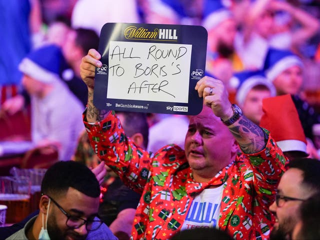 <p>A fan holding a sign mentioning Boris Johnson at the World Darts Championship at Alexandra Palace</p>