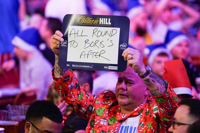 <p>A fan holding a sign mentioning Boris Johnson at the World Darts Championship at Alexandra Palace</p>