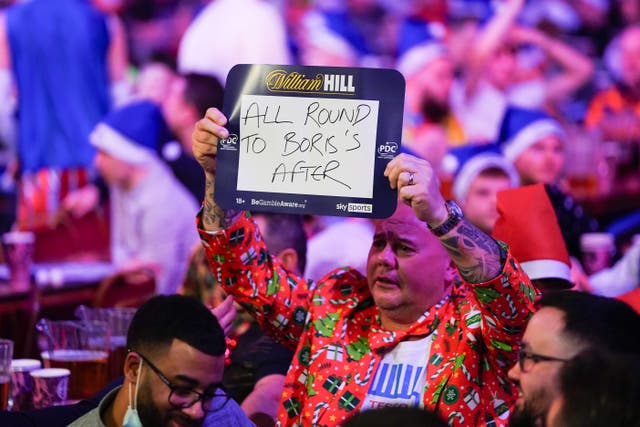 A fan holds an sign poking fun at Boris Johnson (Zac Goodwin/PA)