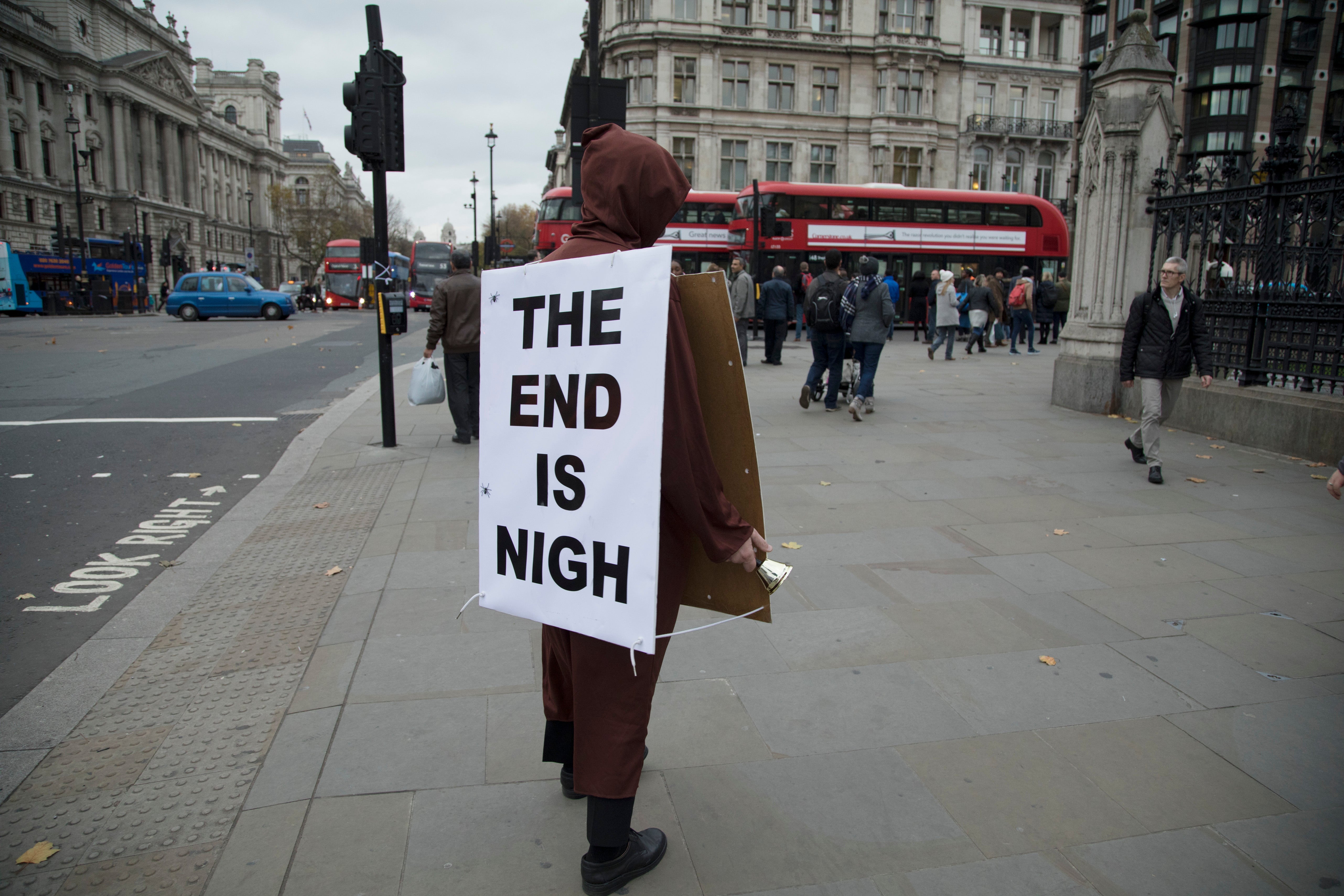 Demonstrator with a sandwich board reading The End Is Nigh protests in Westminster on Budget Day in 2017
