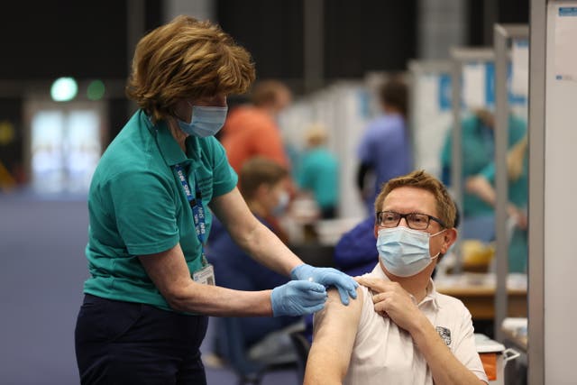 Retired GP Geraldine McKenna gives Andrew Adair his booster jab at a Covid-19 vaccination at the Titanic Exhibition Centre in Belfast (Liam McBurney/PA)