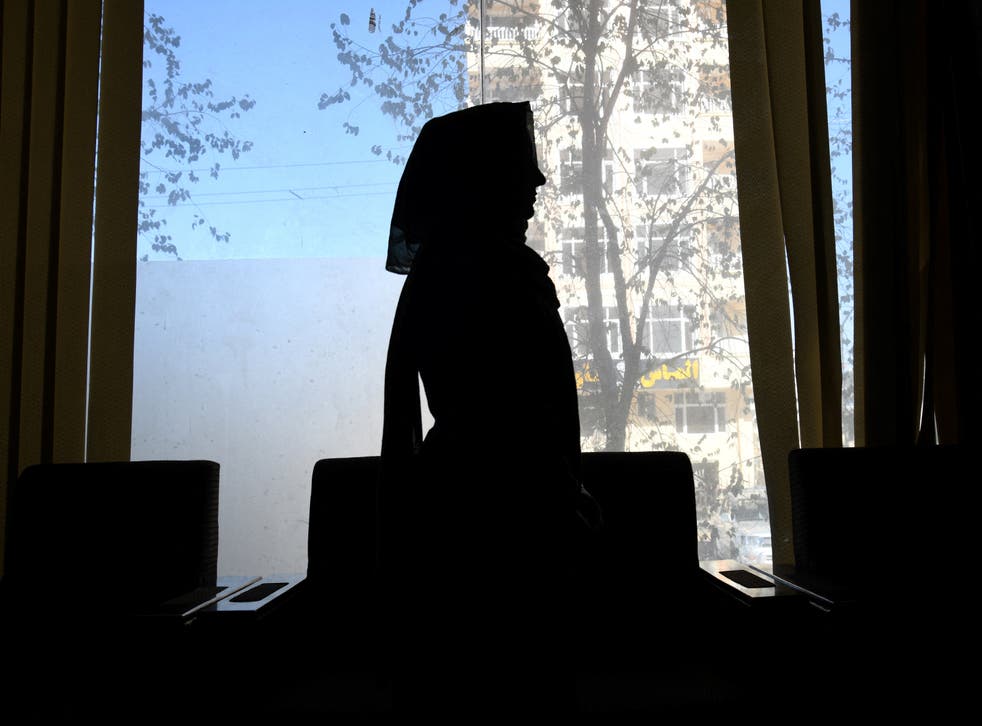 <p>An Afghan former female journalist silhouetted during an interview in Kabul, Afghanistan</p>