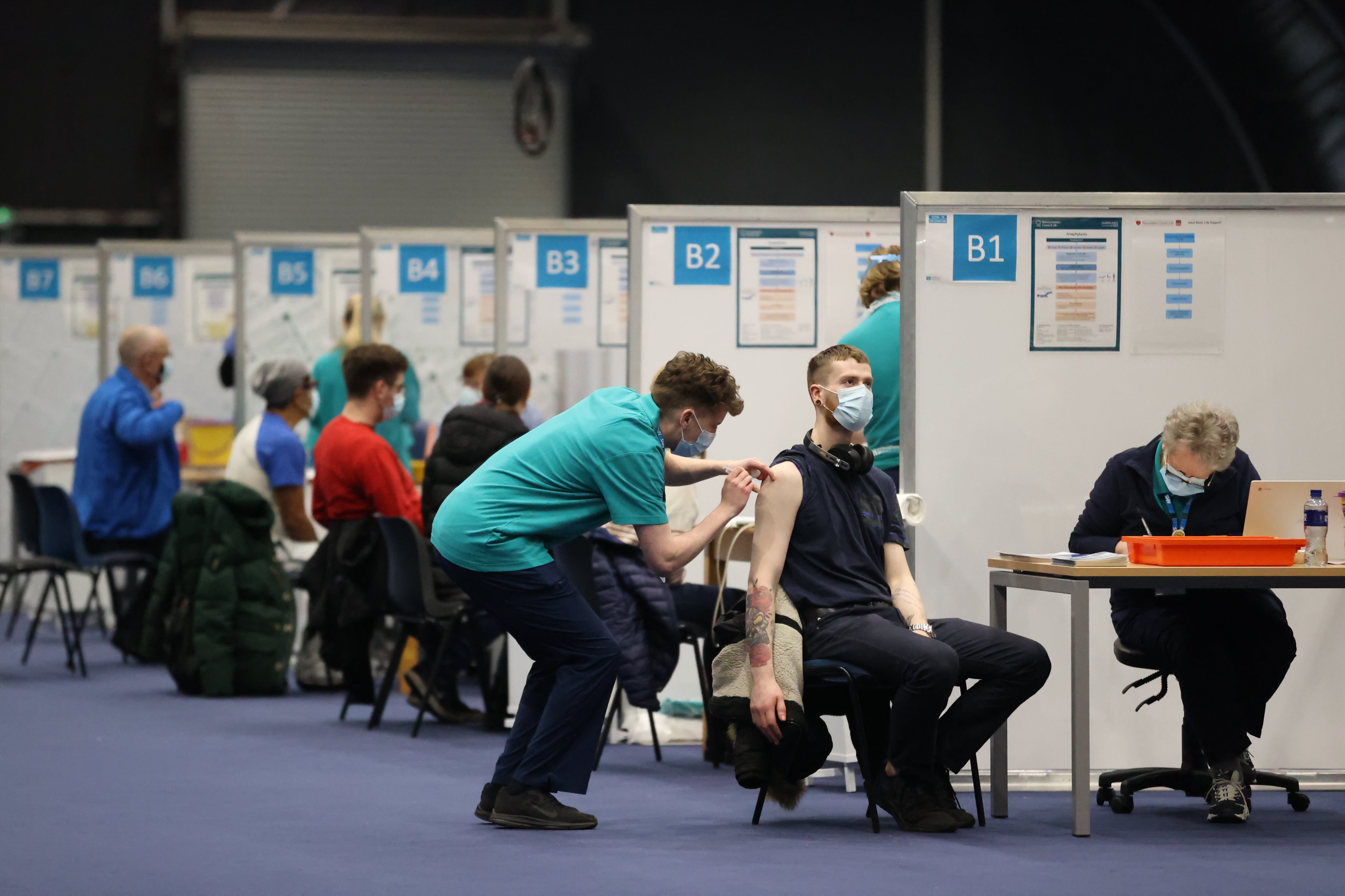 People get vaccinations at a booster vaccination centre at the Titanic Exhibition Centre in Belfast (Liam McBurney/PA)