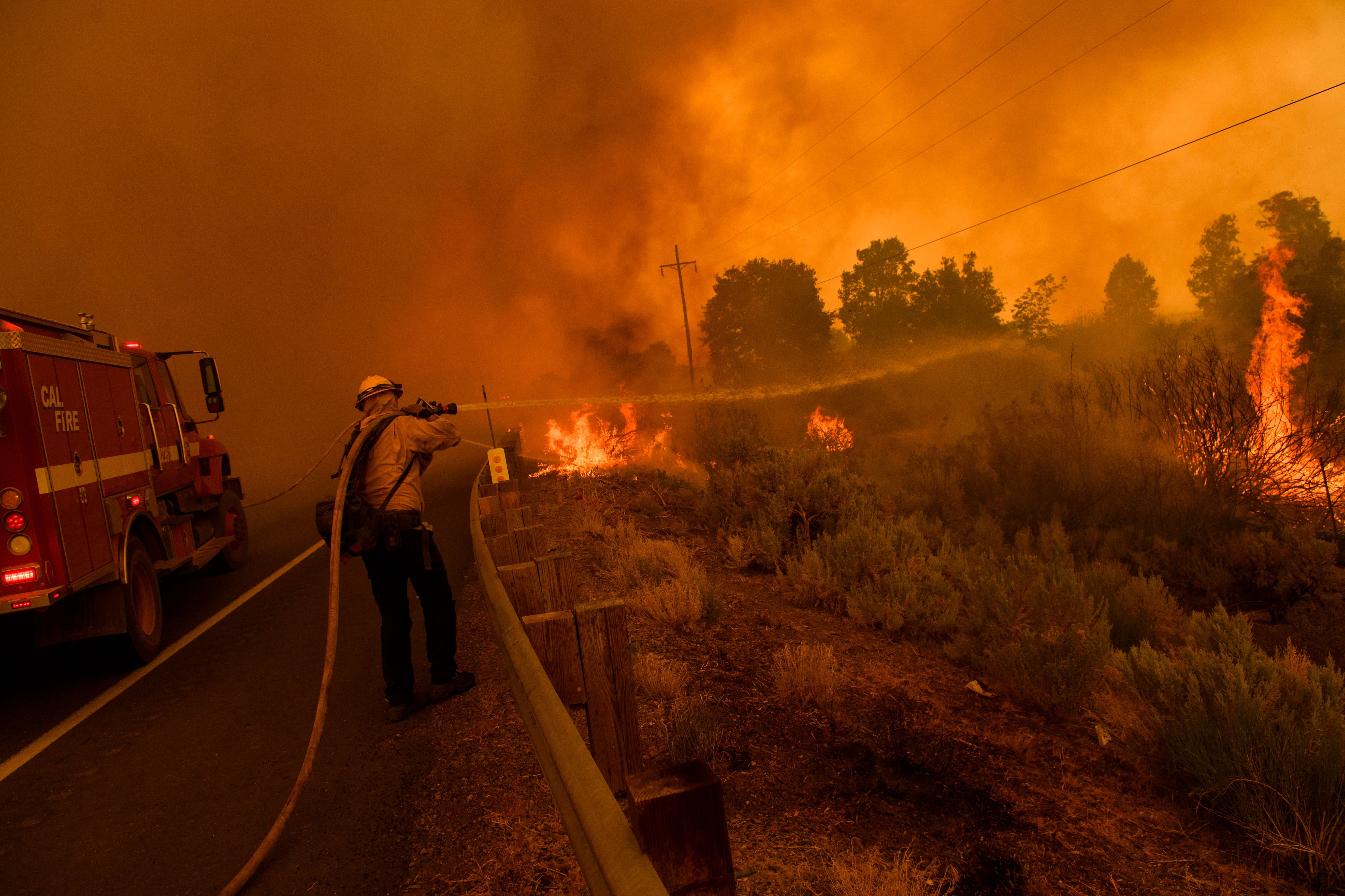 Firefighters work to contain a fire from Highway 395 during the Dixie Fire on 17 August, and was the second largest single wildlife in California state history.