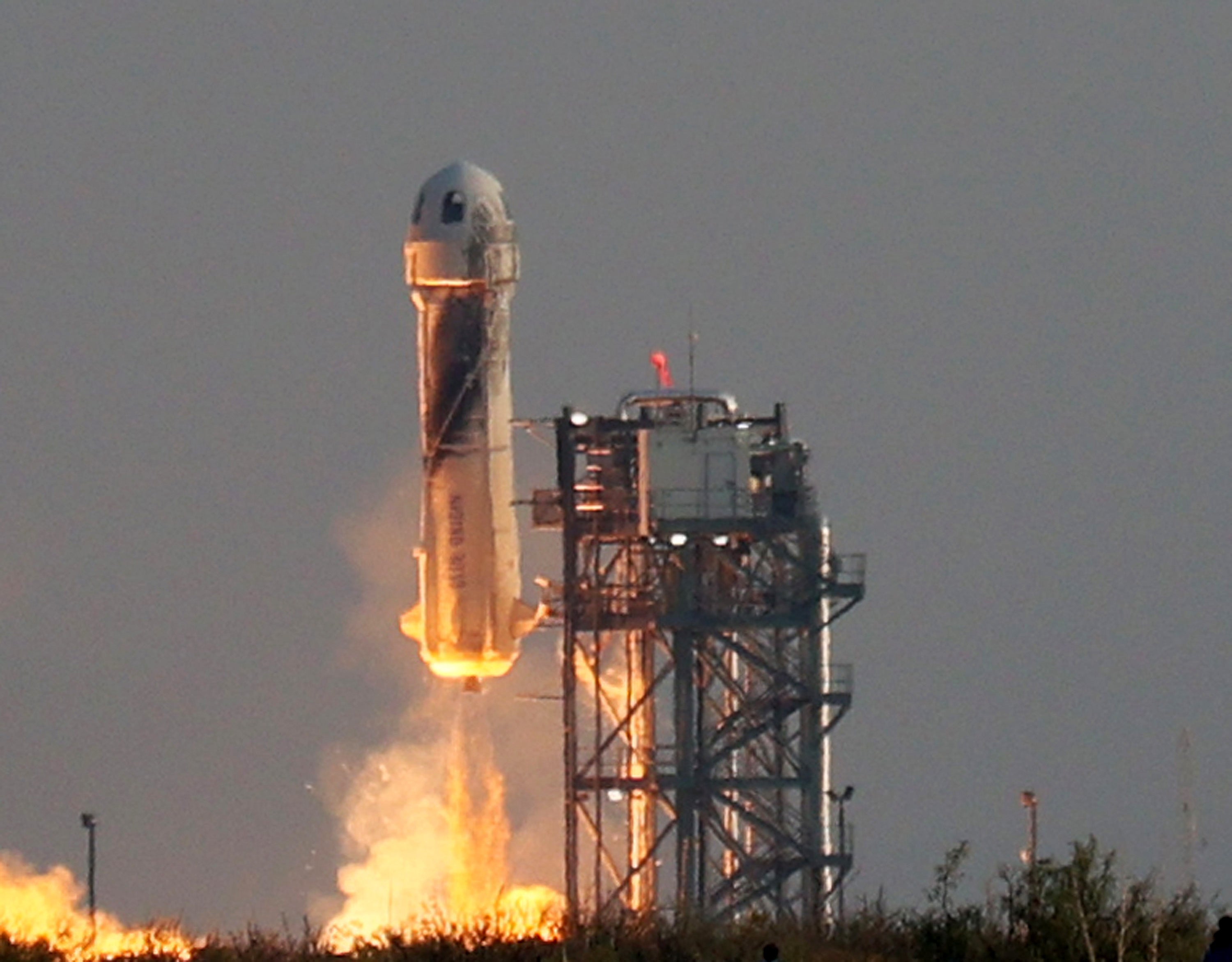 Blue Origin’s New Shepard spacecraft lifts-off from the launch pad carrying Jeff Bezos along with his brother Mark Bezos, 18-year-old Oliver Daemen, and 82-year-old Wally Funk on 20 July, from Van Horn, Texas.