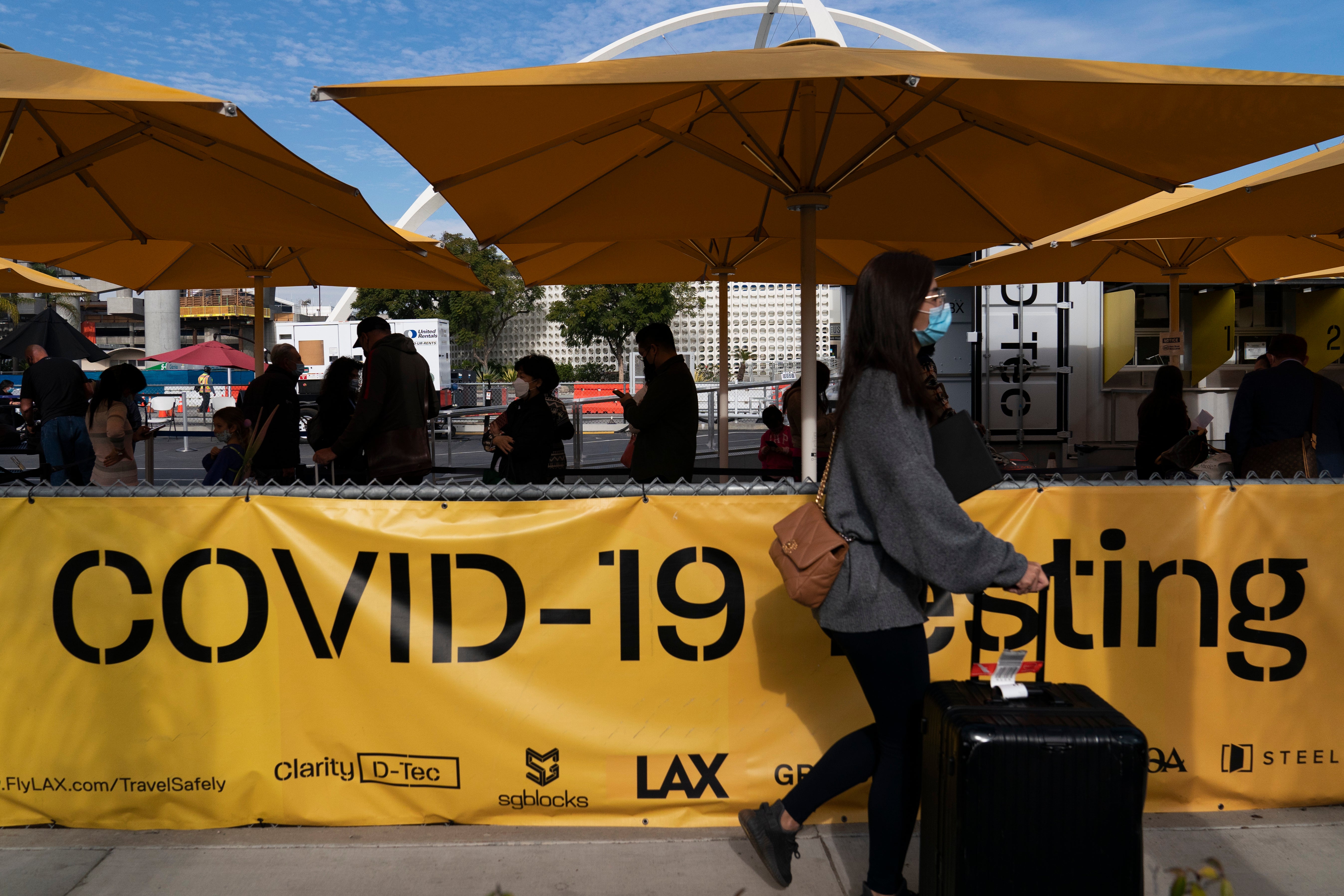 Travelers wait in line to get tested for Covid-19 at Los Angeles International Airport