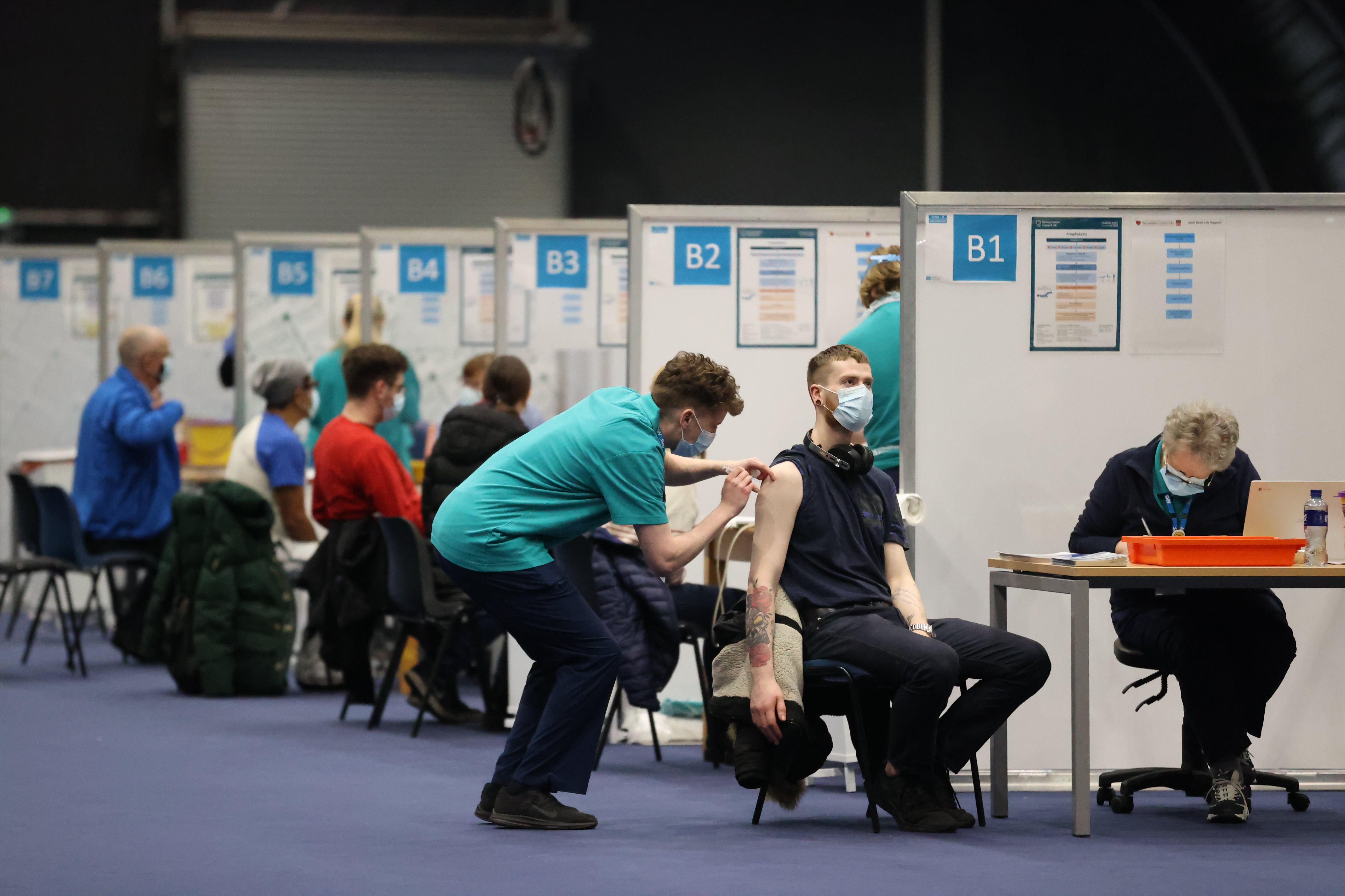 People get vaccinations at a Covid-19 booster vaccination centre at the Titanic Exhibition Centre in Belfast (Liam McBurney/PA)