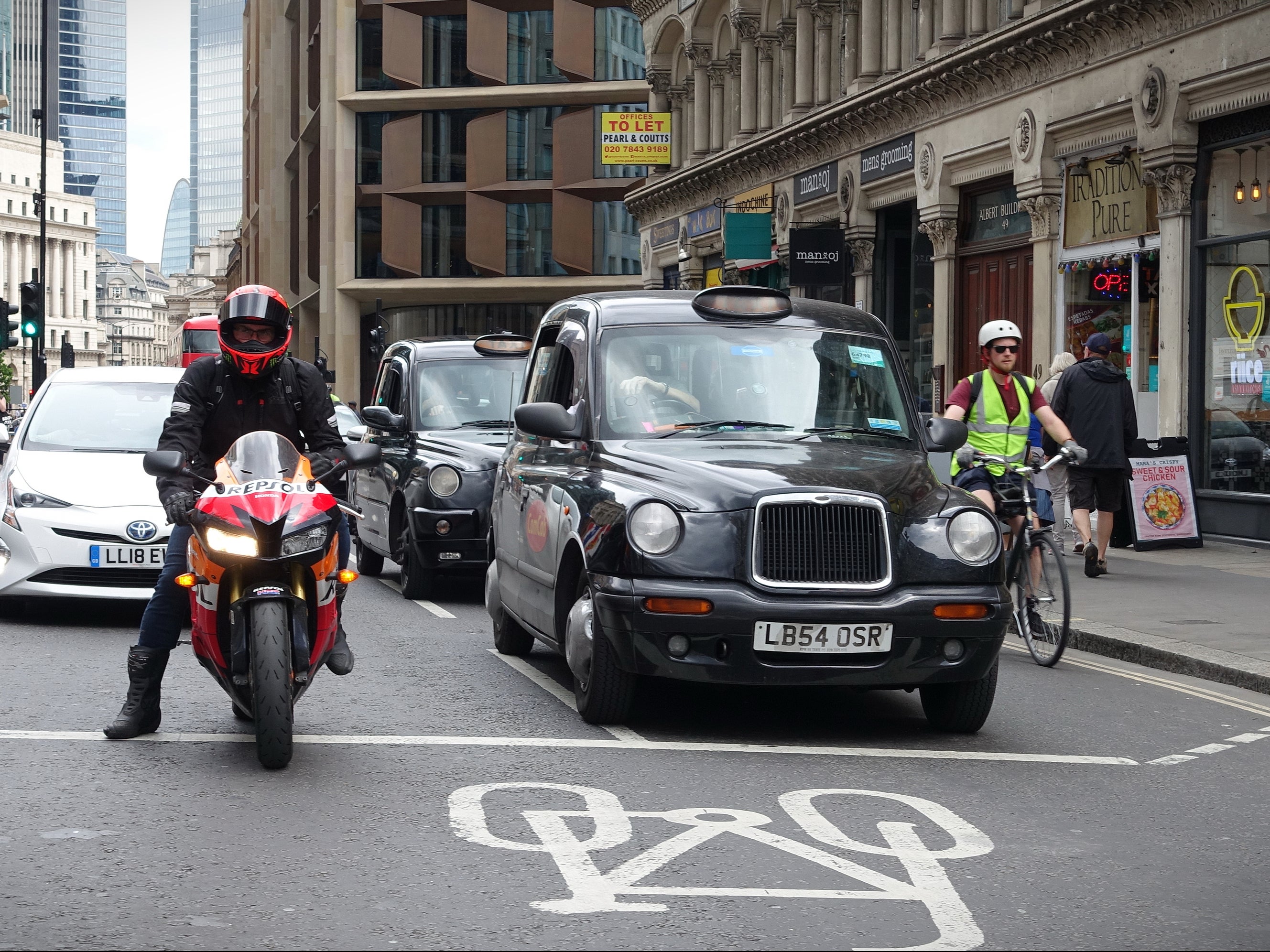 Traffic passes along a busy road in the City of London