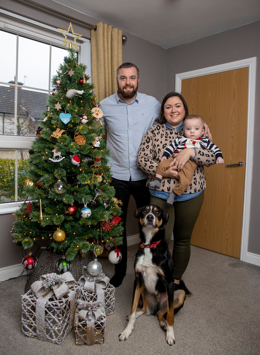 Martin and Gillian Johnston with their son Robert “Robbie’ Johnston and their rescue dog Max at their home in Ballyclare, Northern Ireland. PA Photo. Picture date: Tuesday December 21 2021. See PA story ULSTER Baby. Photo credit should read: Liam McBurney/PA Wire
