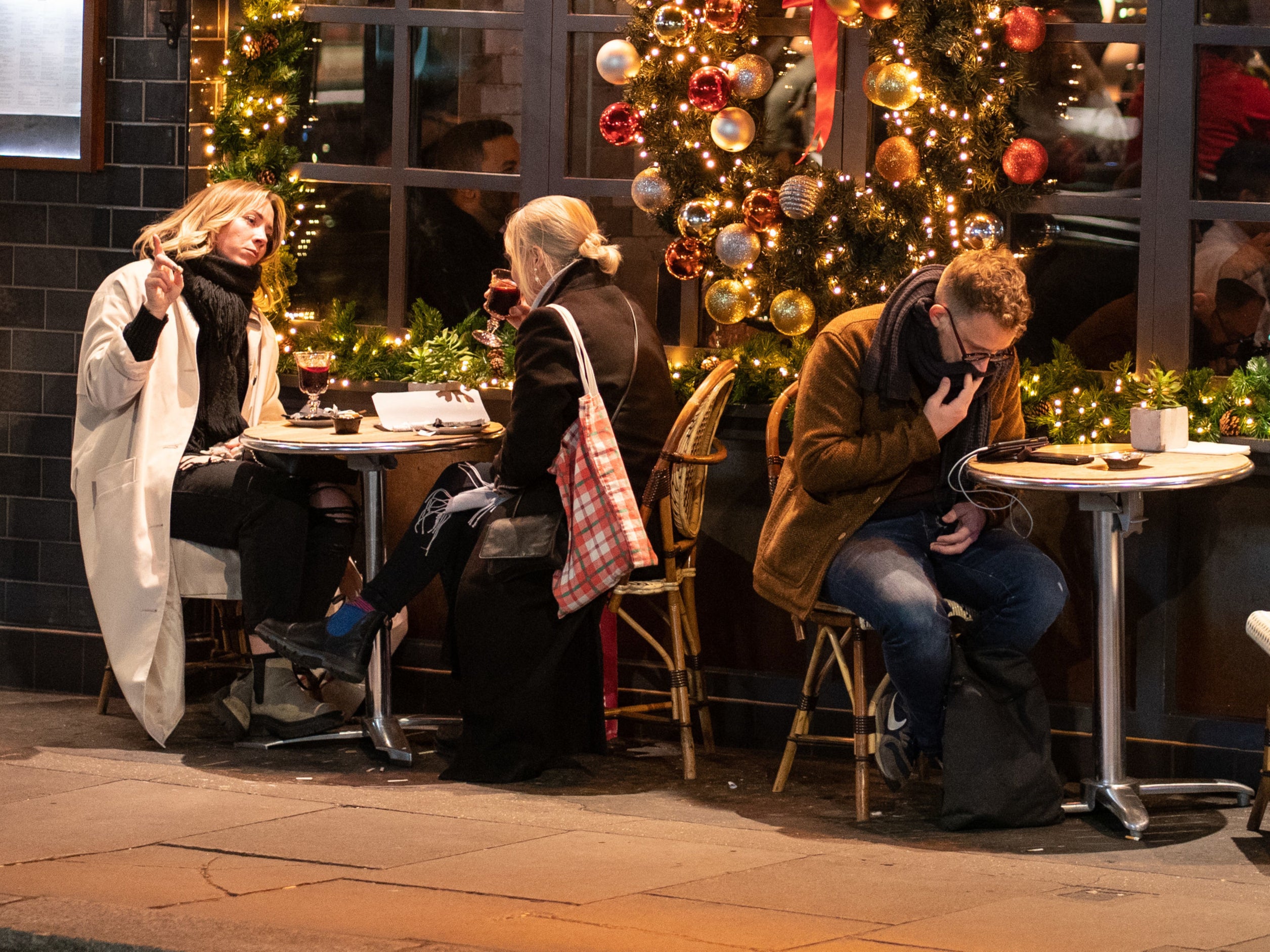 People eat outside a pub in London, as the government ruled out introducing further restrictions in England ahead of Christmas