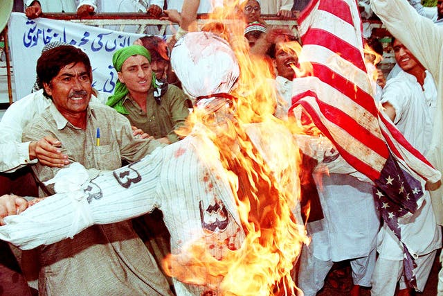 <p>Members of Pakistan's religious group Sipah Sahaba Pakistan burn an effigy of Bill Clinton and an American flag in Karachi in protest at the US airstrikes on Afghanistan </p>