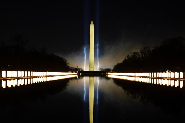 <p>The Washington Monument lit up on 20 January in memory of 400,000 Americans who had died of Covid</p>
