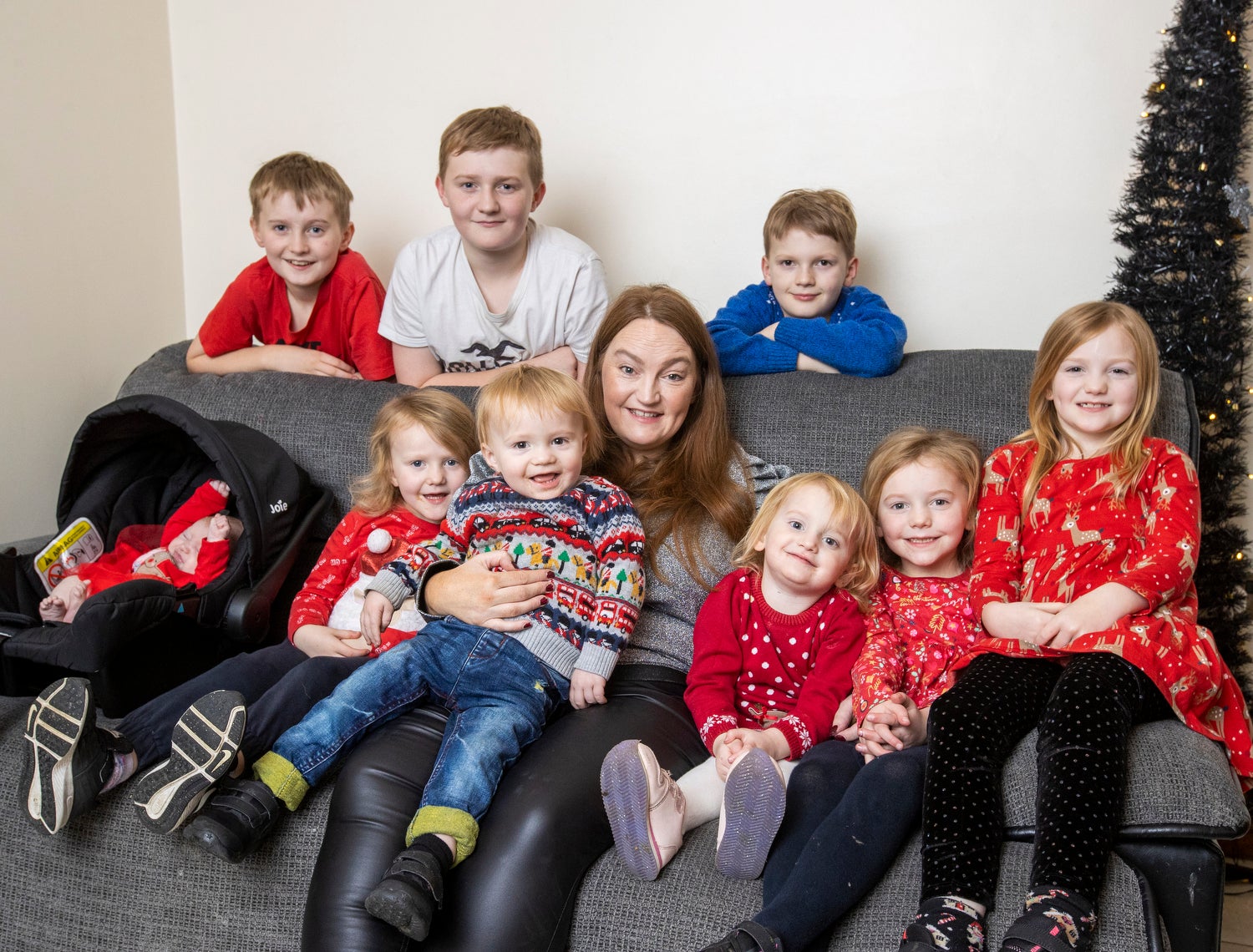 Christmas with the Johnstons. Jennifer Johnston with her seven week old baby girl Freya, Jaxon 22 months, Ebony 3, Heidi 4, Sofia 6, Lydia 8, Alfie 9, Joell 12, and Kaleb 14 at their home in Newry (Liam McBurney/PA)