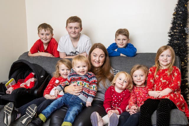 Christmas with the Johnstons. Jennifer Johnston with her seven week old baby girl Freya, Jaxon 22 months, Ebony 3, Heidi 4, Sofia 6, Lydia 8, Alfie 9, Joell 12, and Kaleb 14 at their home in Newry (Liam McBurney/PA)