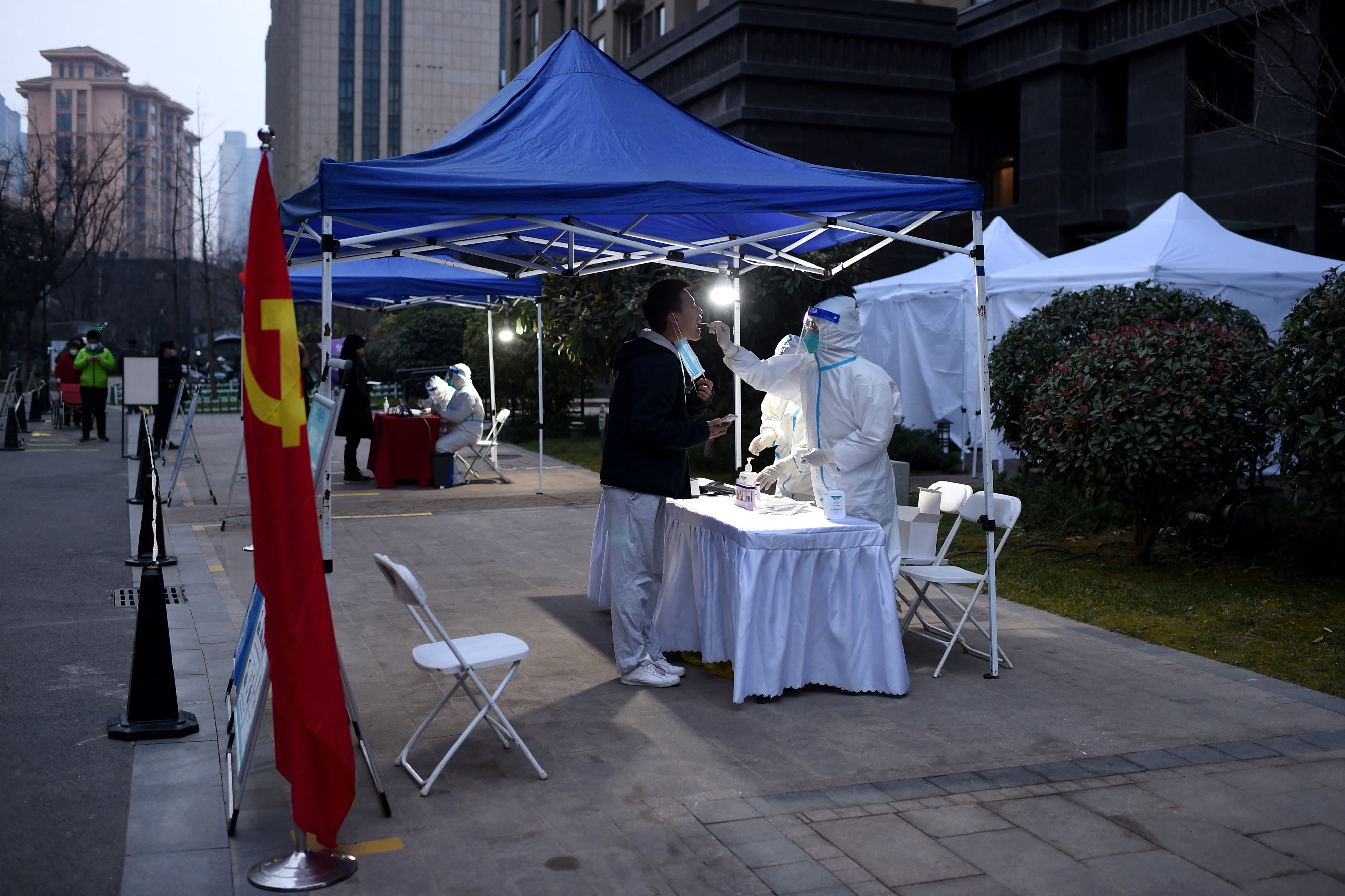 File: A resident undergoes a nucleic acid test for Covid at a residential area that is under restrictions following a recent coronavirus outbreak in Xi’an